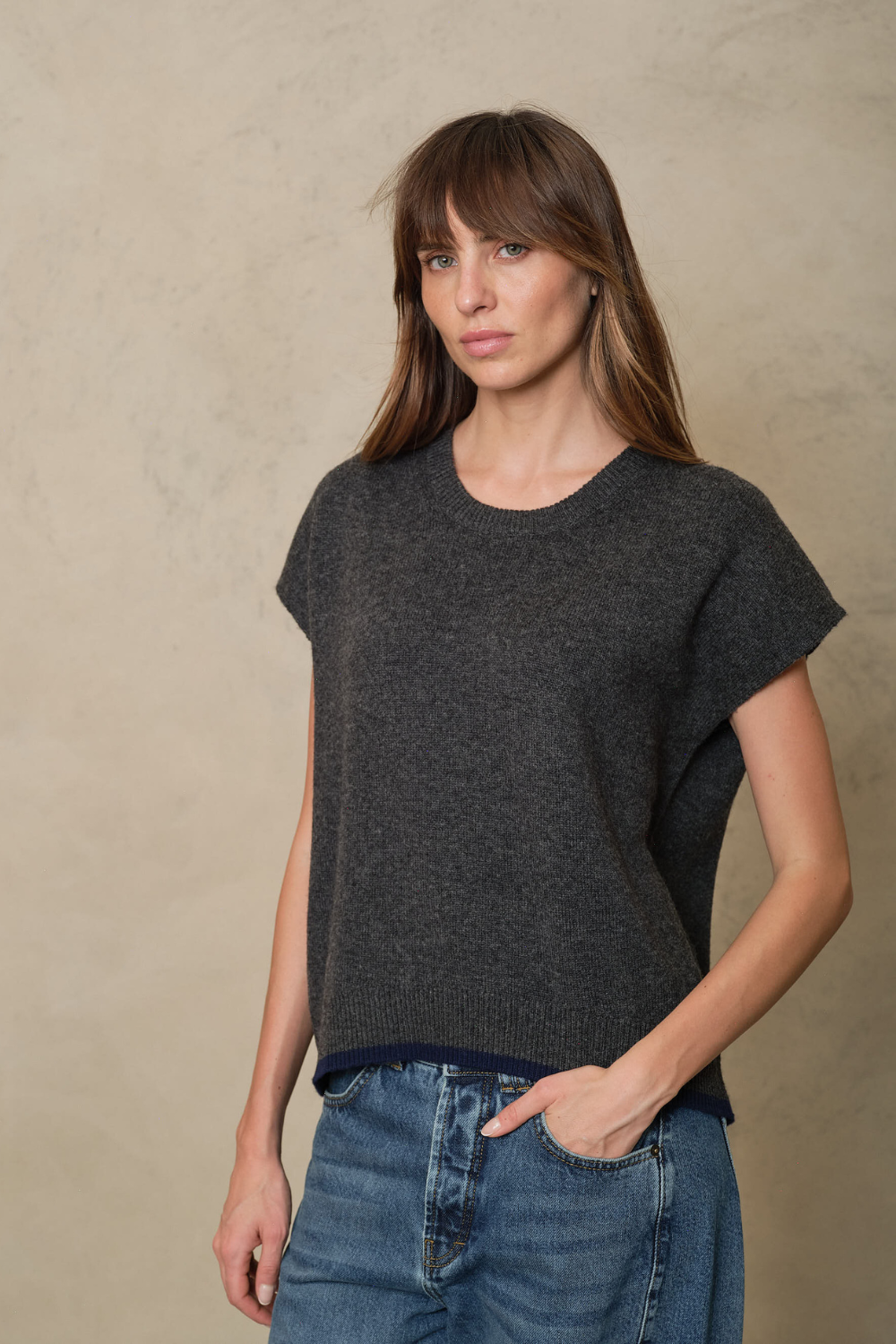 Ora charcoal knitted vest showing the grown on cap sleeve, three quarter view