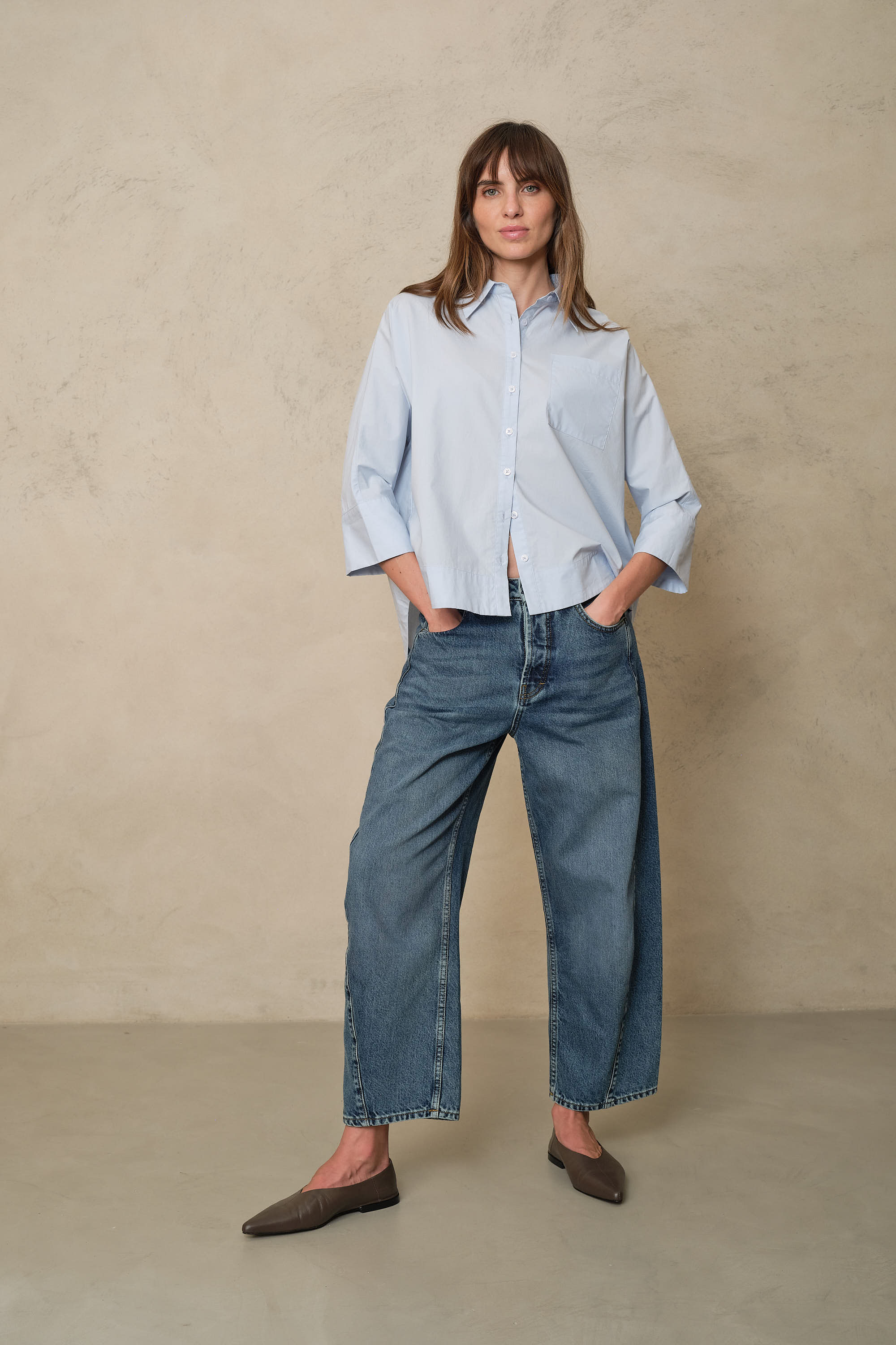 Rosie mid wash twist front jeans styled with a pale blue shirt and brown flats