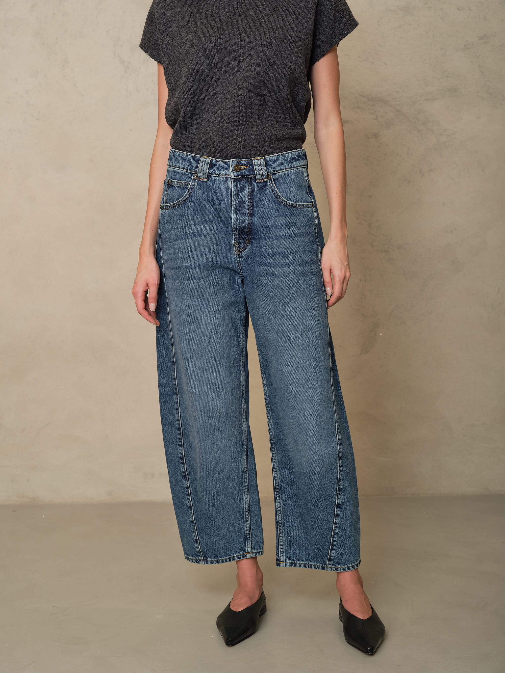 Rosie mid wash twist front jeans worn with a charcoal T Shirt and black flats
