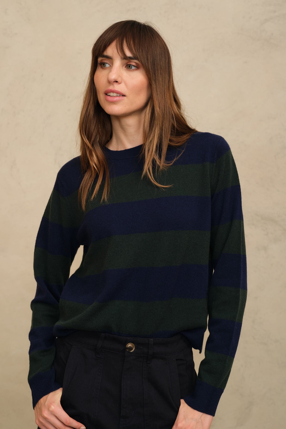 Navy and bottle green striped jumper worn tucked into black trousers