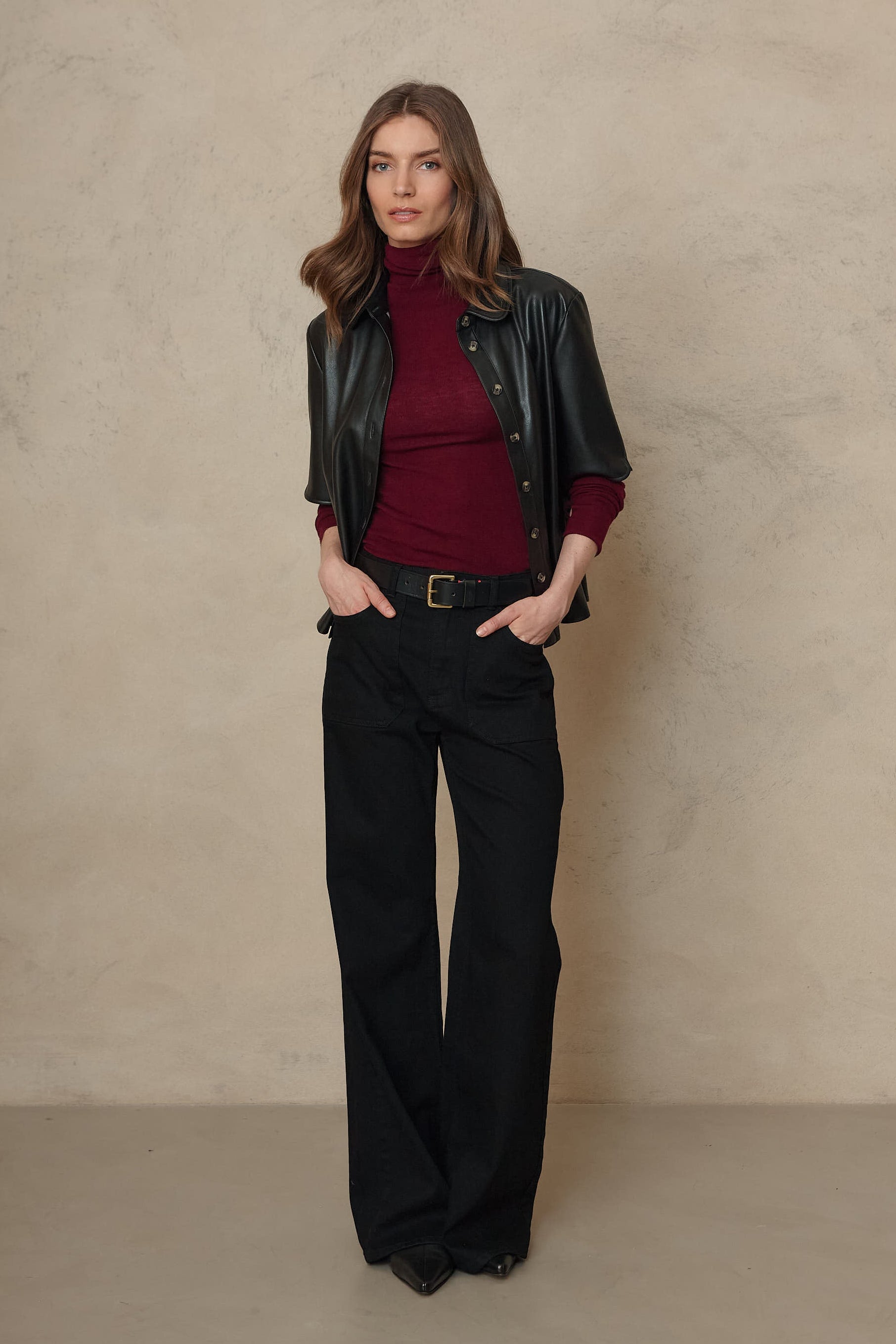 Frankie black wide leg jeans worn with a burgundy roll neck and a black leather jacket