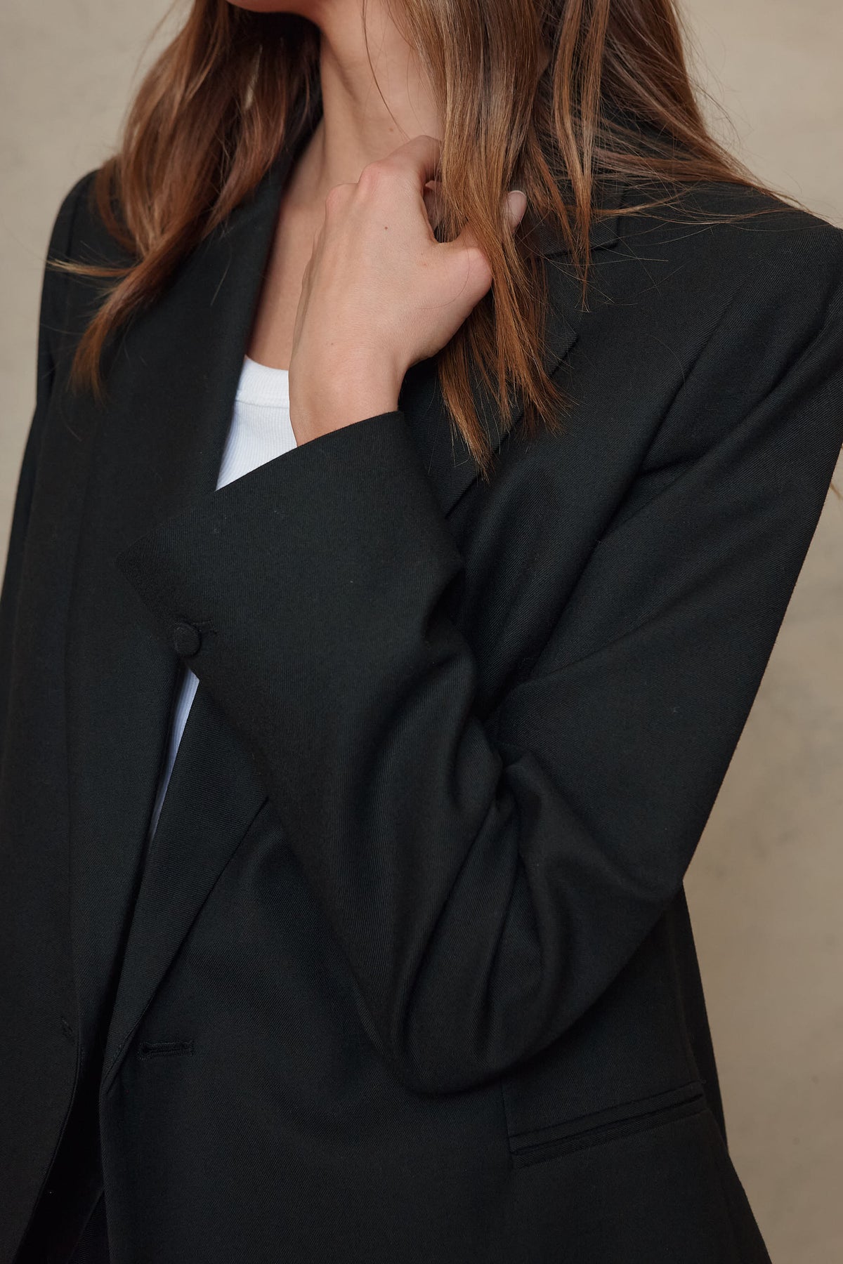 Josephine black wool blend blazer worn open over a white top, close up