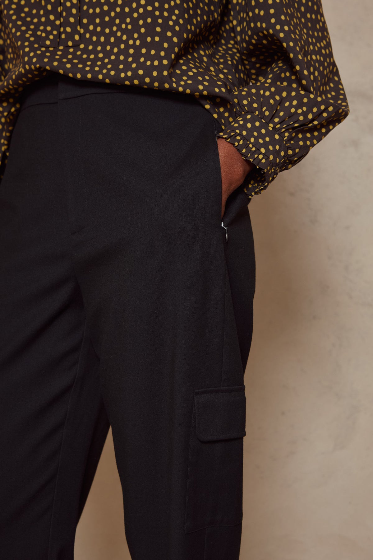 Close up of the side pocket on the Tess clean cargo trousers in black