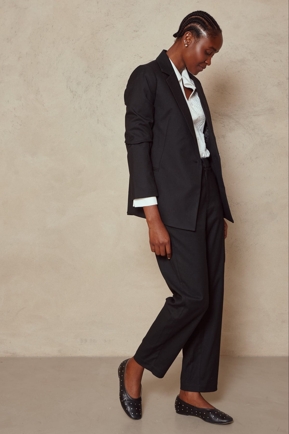 Model wearing the Tess clean cargo trousers in black with a black blazer, white shirt and flats
