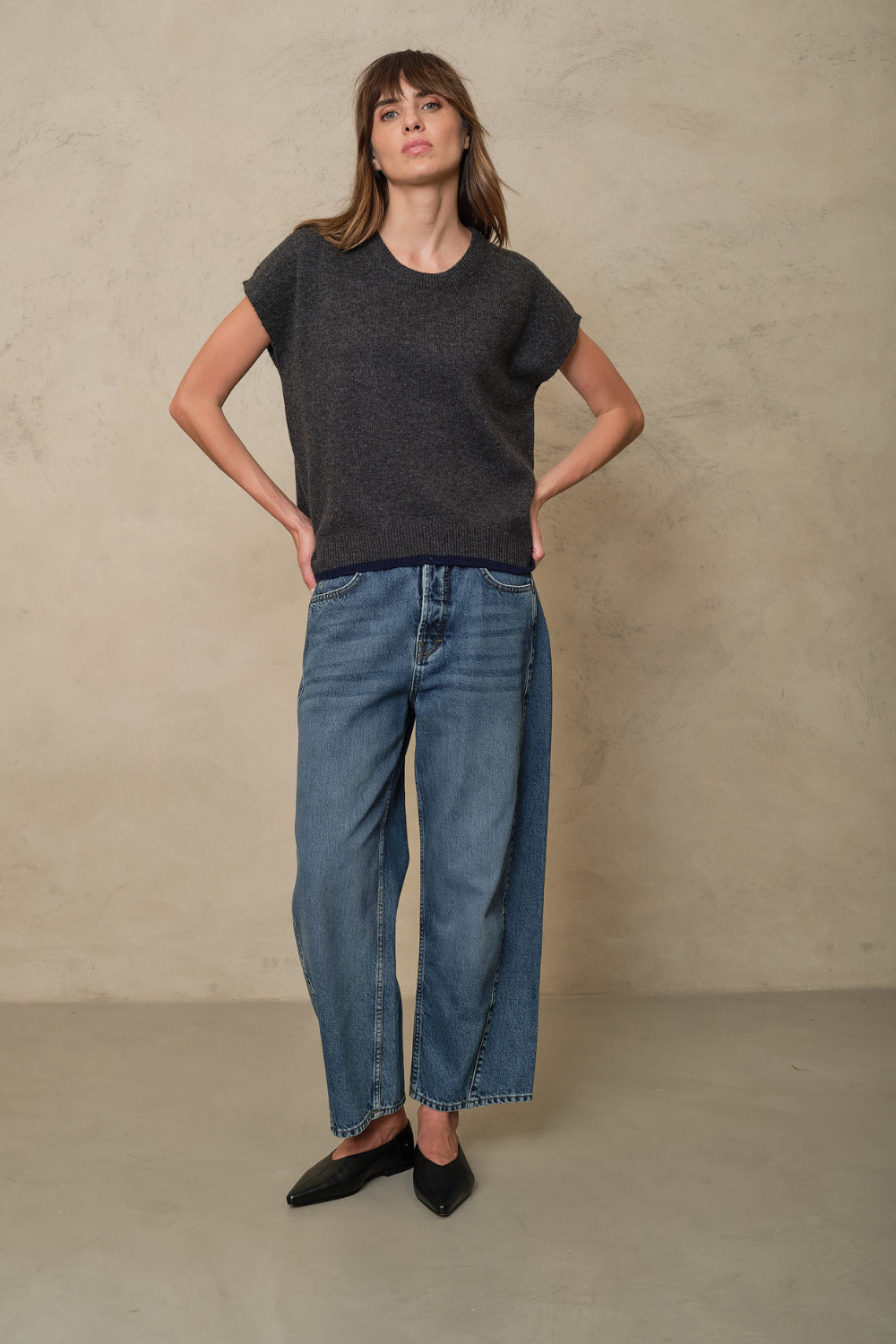 Ora charcoal knitted vest styled with wide leg jeans and black flats, full length