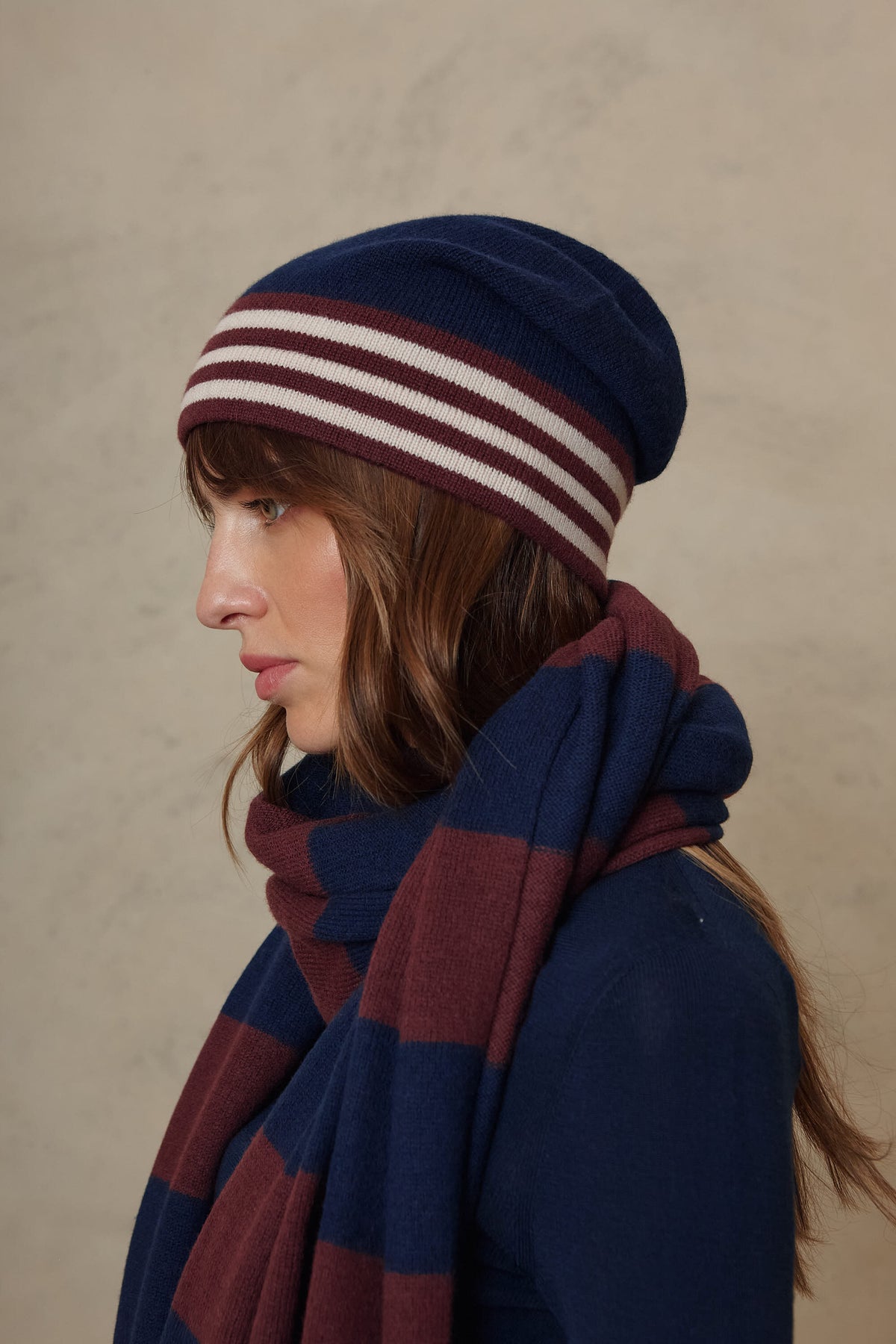 Zinnie cashmere blend beanie in navy worn with the Carmel cashmere blend scarf in navy and burgundy