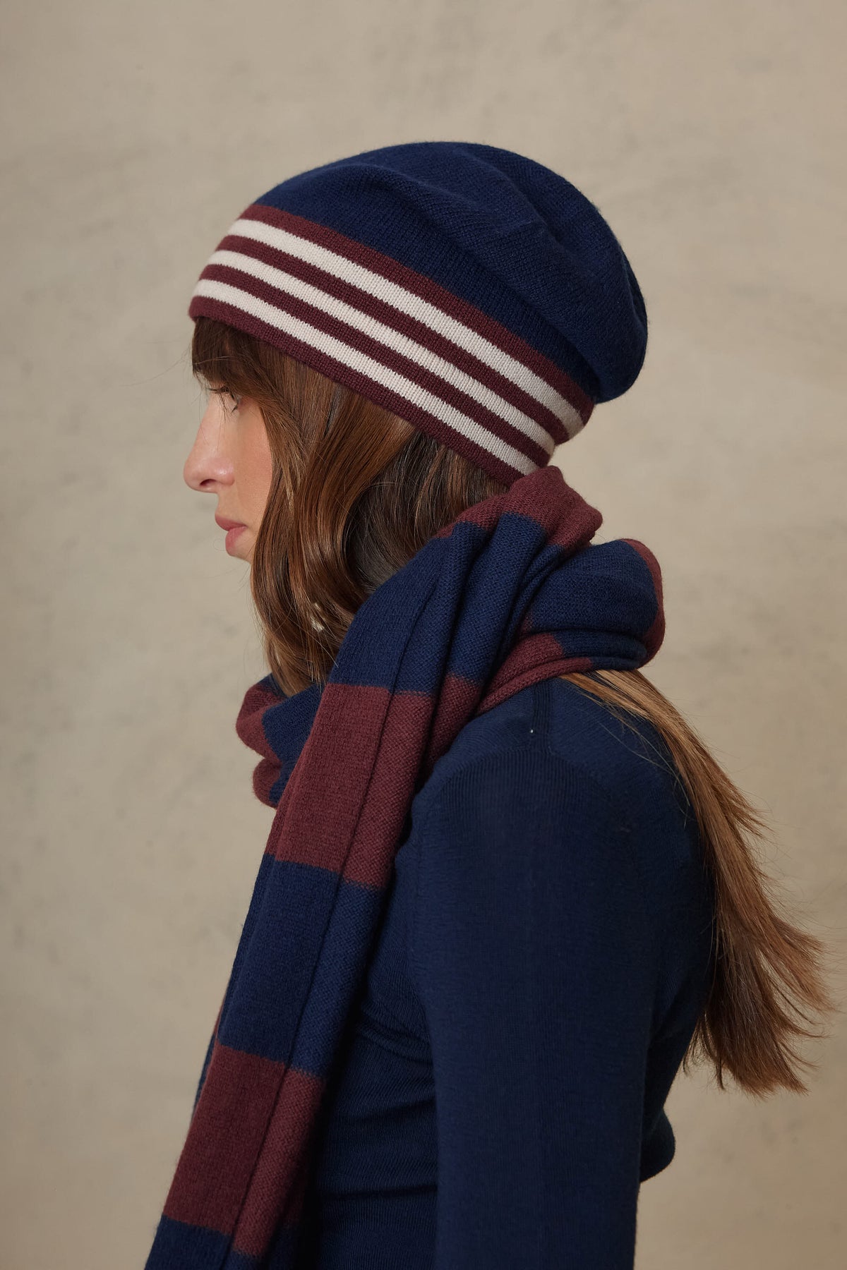 Zinnie cashmere blend beanie in navy worn with the Carmel cashmere blend scarf in navy and burgundy