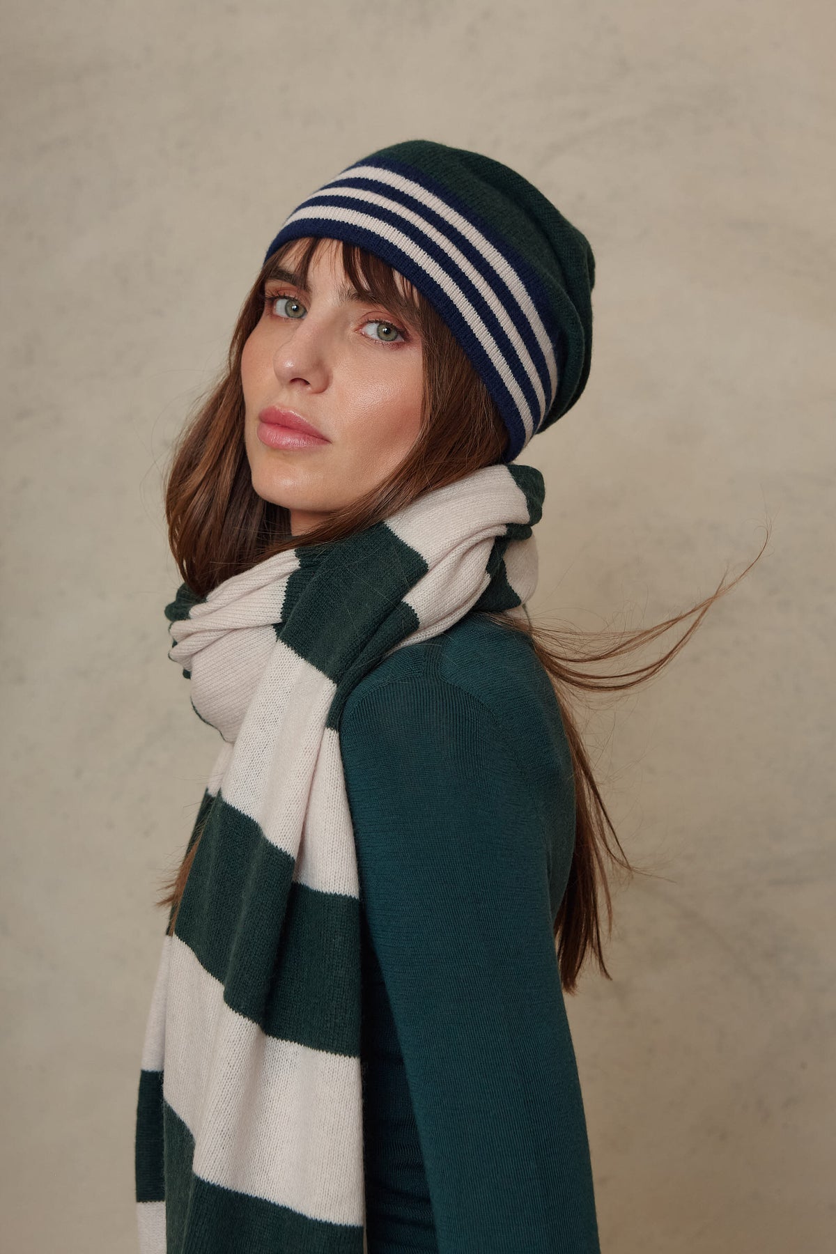 Zinnie cashmere blend beanie in bottle green worn with the Carmel cashmere blend scarf in soft stone and bottle green