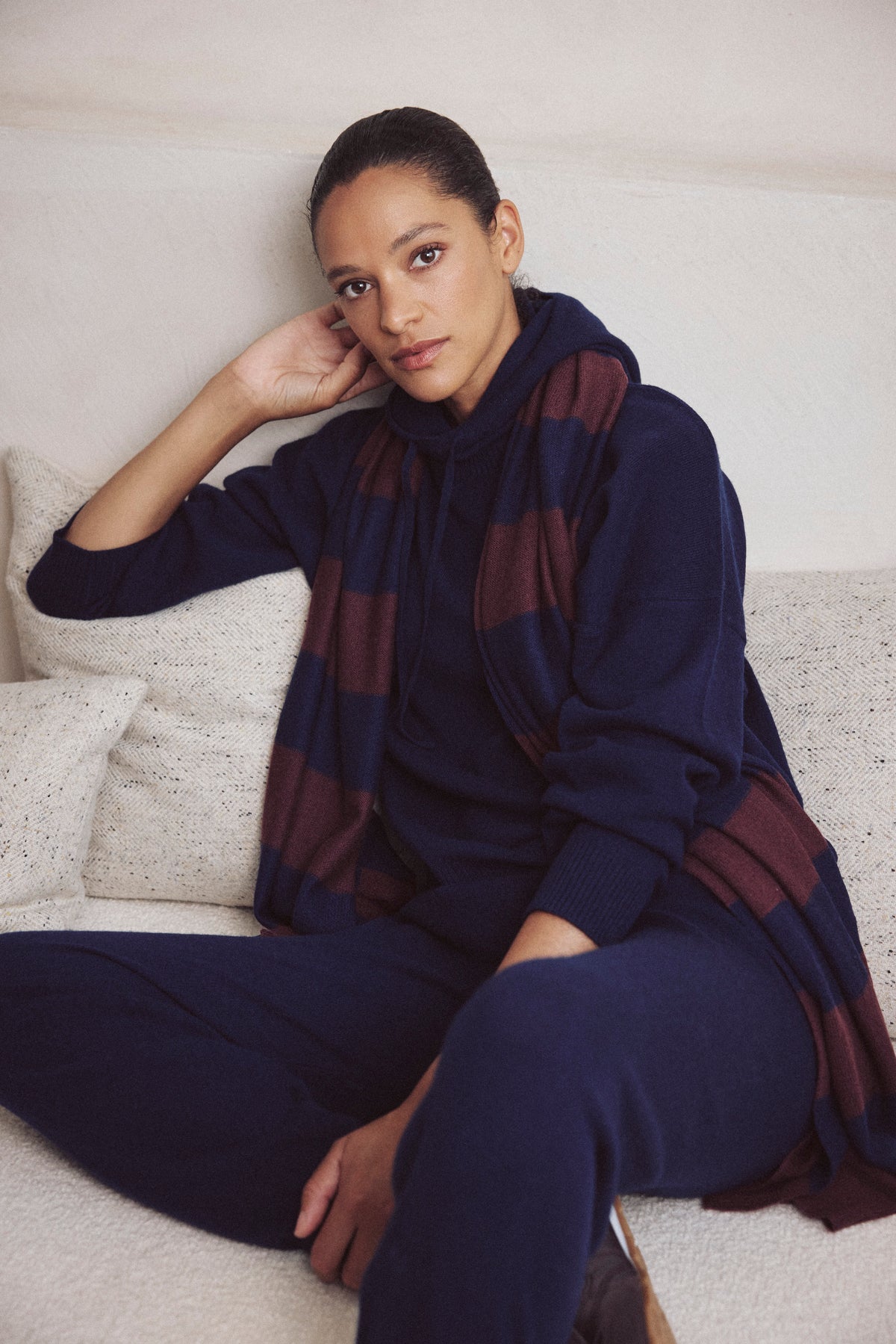 Carmel cashmere blend scarf in navy and burgundy worn with the Heidi cashmere blend hoodie in navy, seated