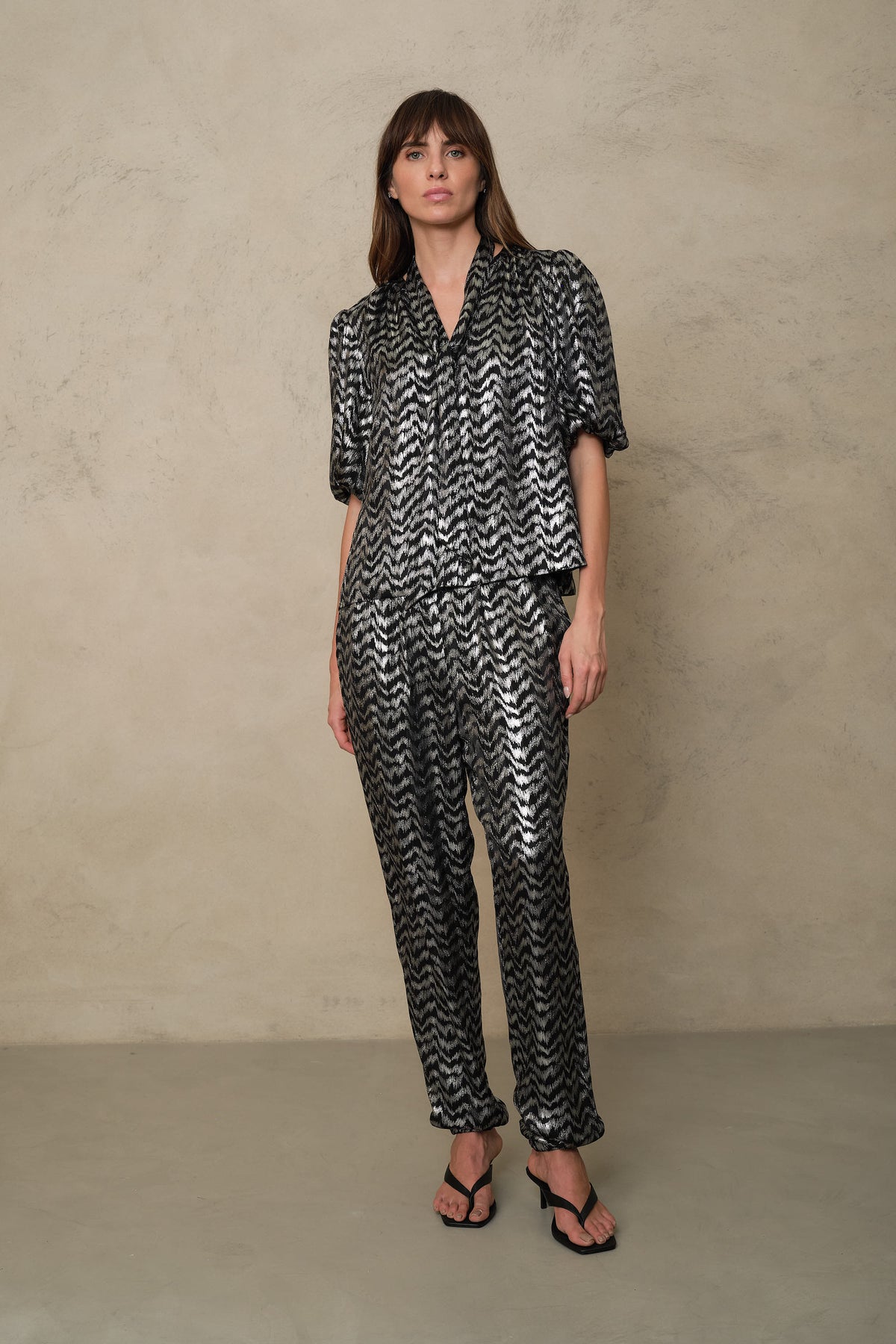 Poppy puff sleeve blouse in silver stripe worn as a co ord with sandals, full length