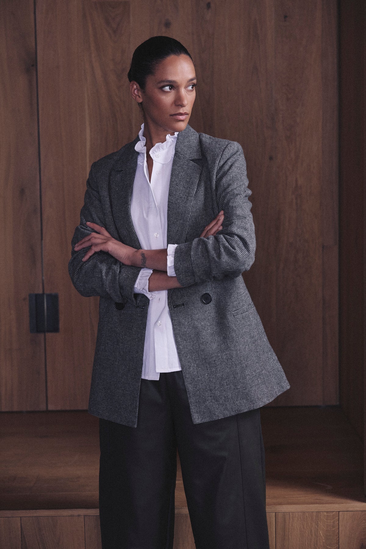 Houndstooth tweed blazer styled over an ivory ruffle collar shirt and black wide leg trousers