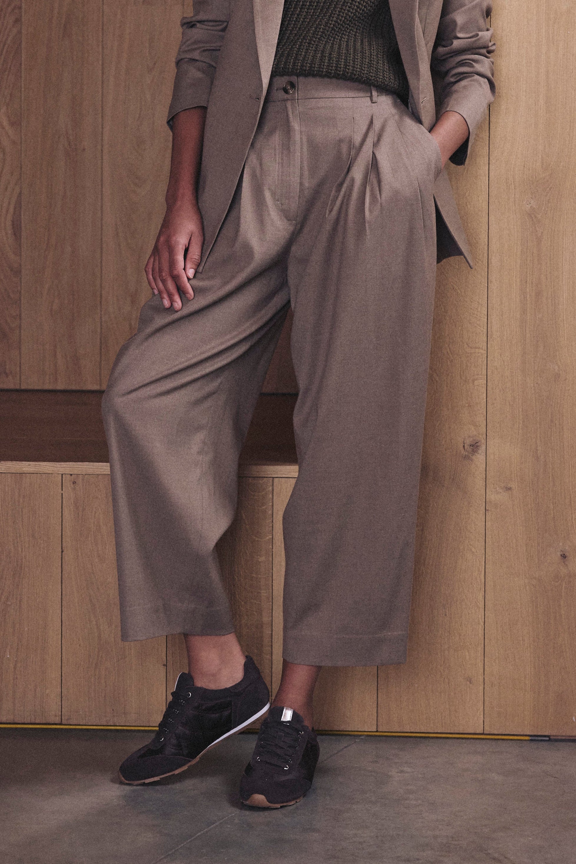 Beige pleat front trousers showing the flat front pleats and cropped leg, worn with the matching Josephine taupe blazer and trainers
