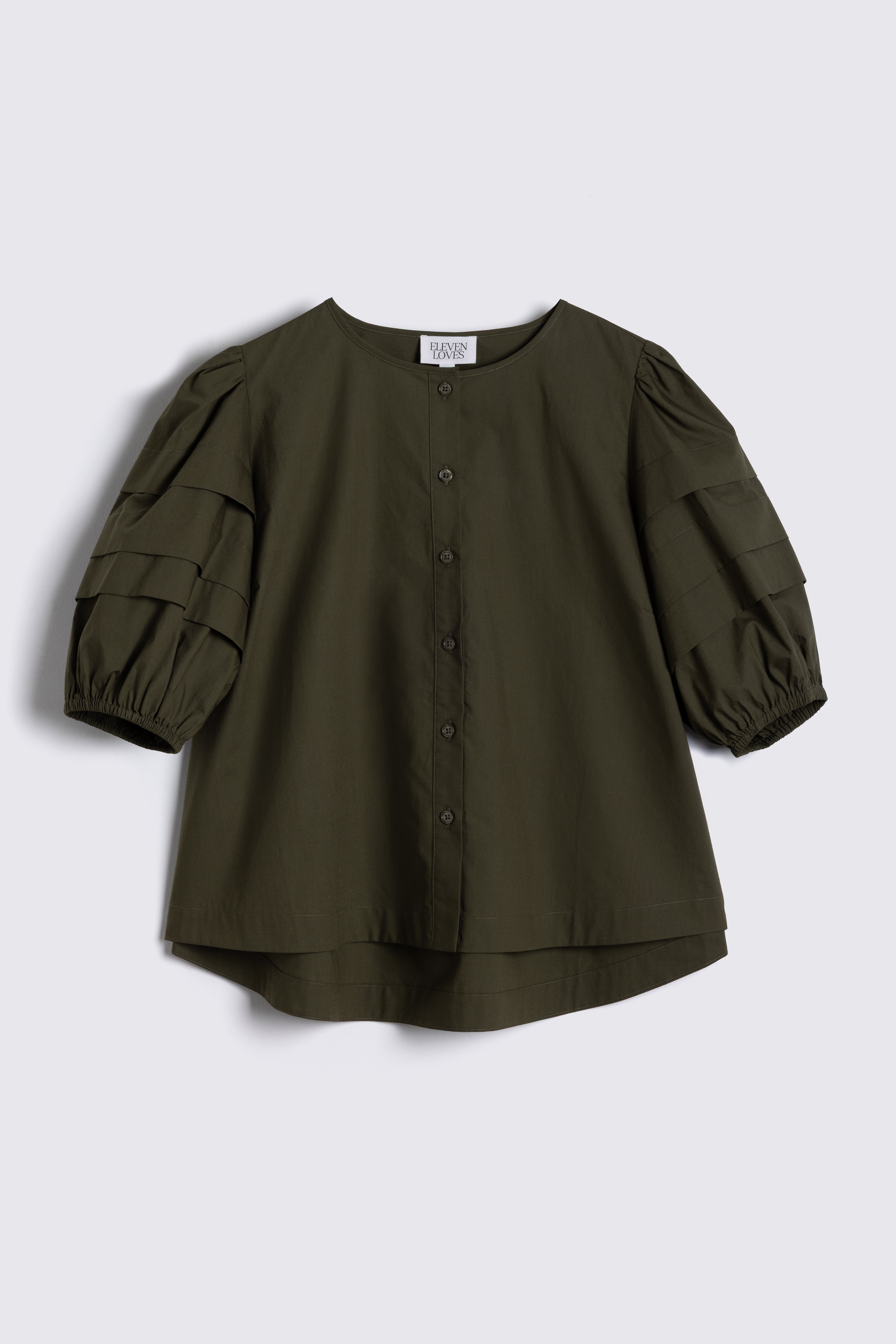 Green blouse with puff sleeves on a light gray background