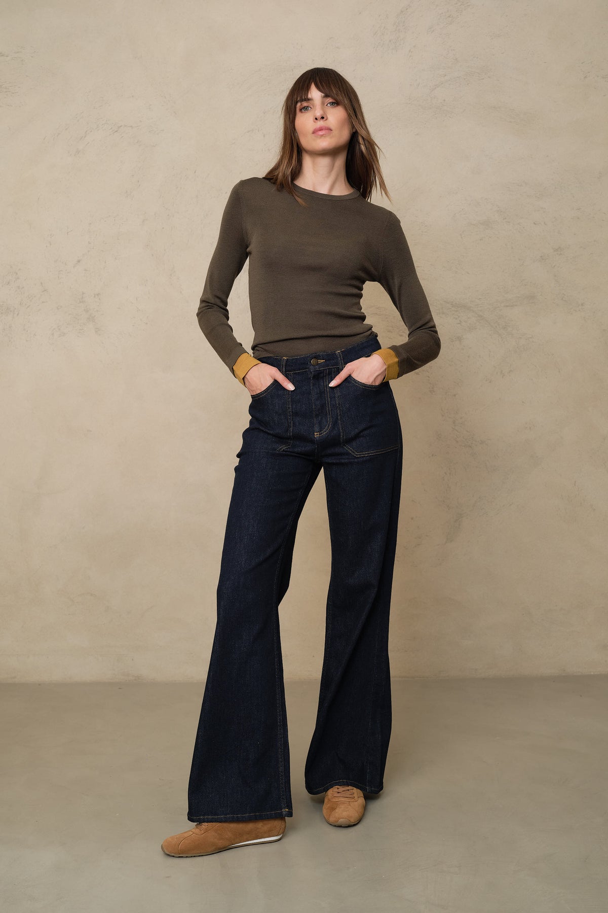 Trinny fine merino crewneck in dark olive with a mustard sleeve worn with the Frankie wide leg jeans in rinse wash