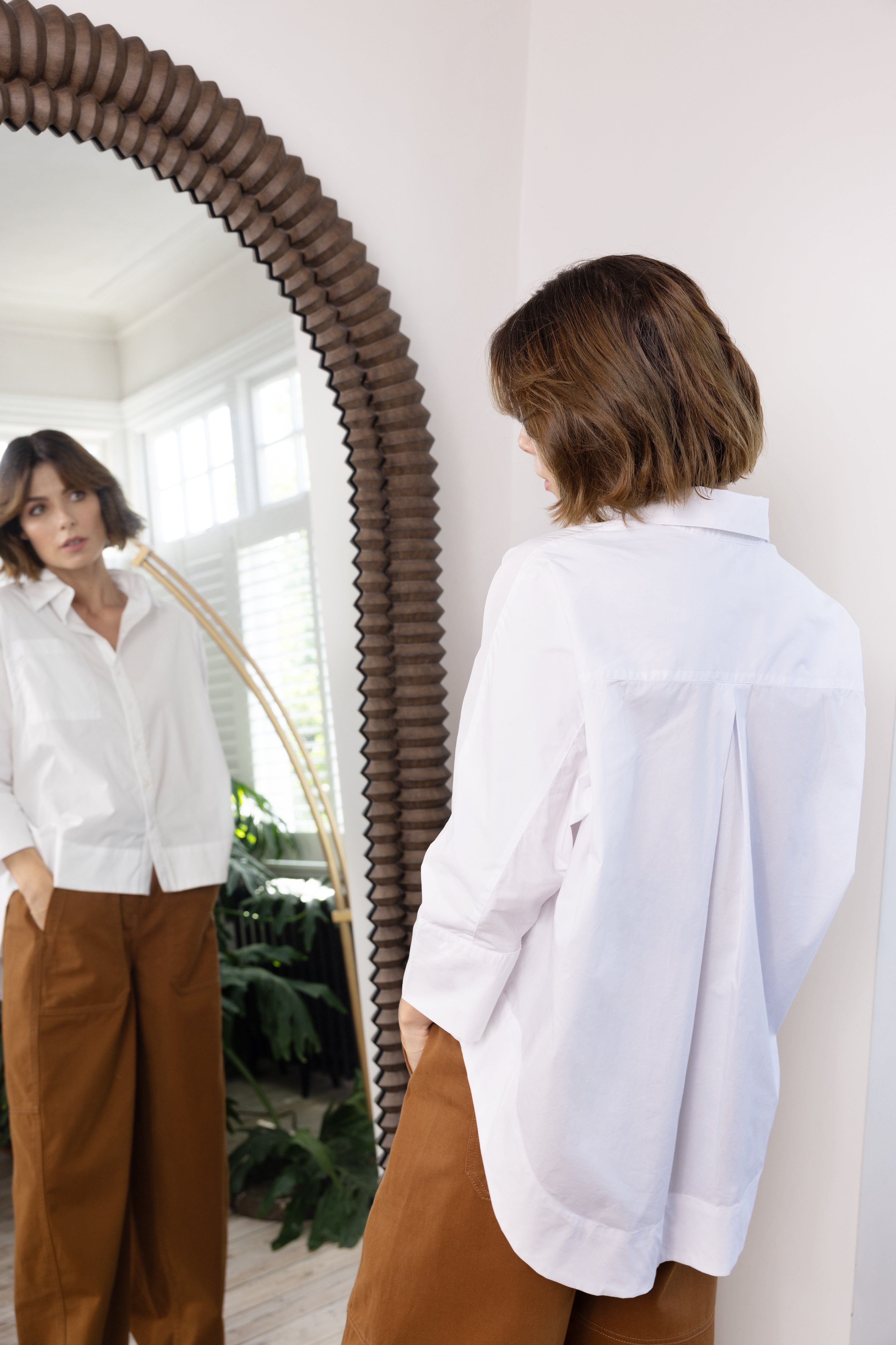 model wearing white poplin shirt and camel trousers