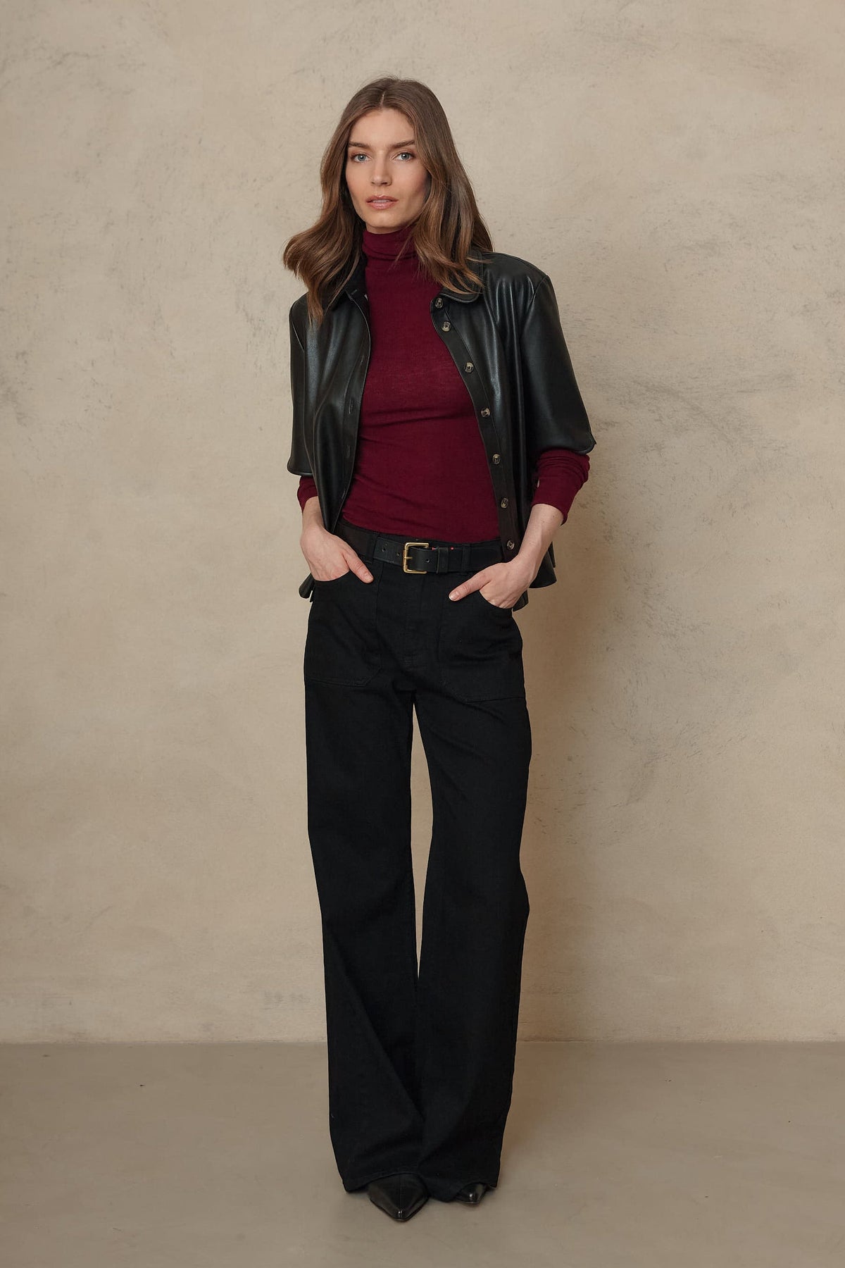 Frankie black wide leg jeans worn with a burgundy roll neck and a black leather jacket