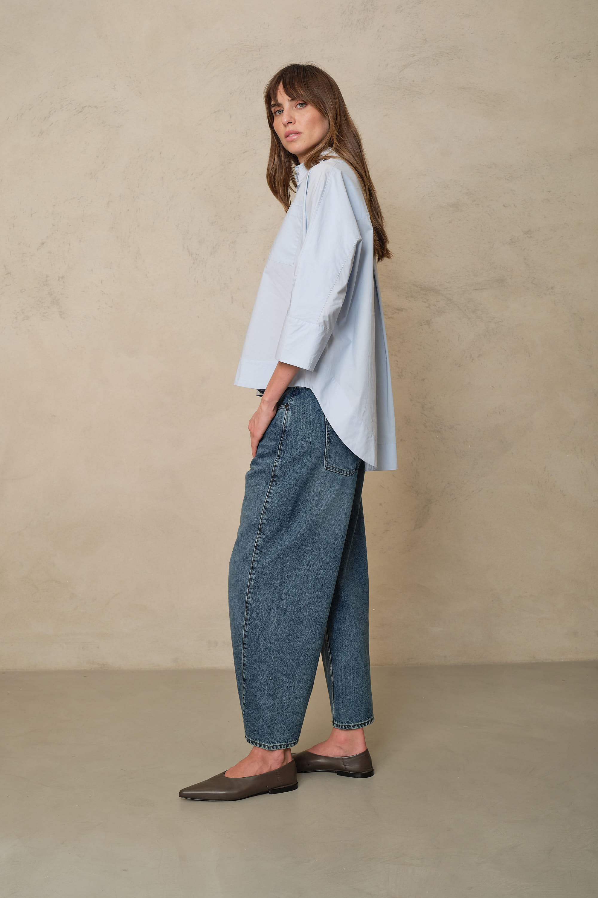 Rosie mid wash twist front jeans showing the curved twist seam leg, side view