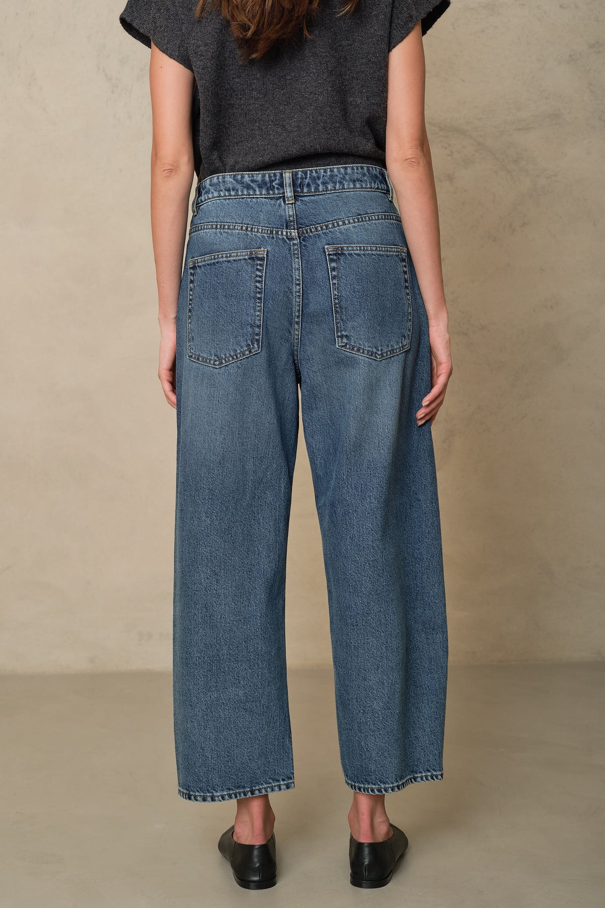 Rosie mid wash twist front jeans showing the back pockets and hem, back view