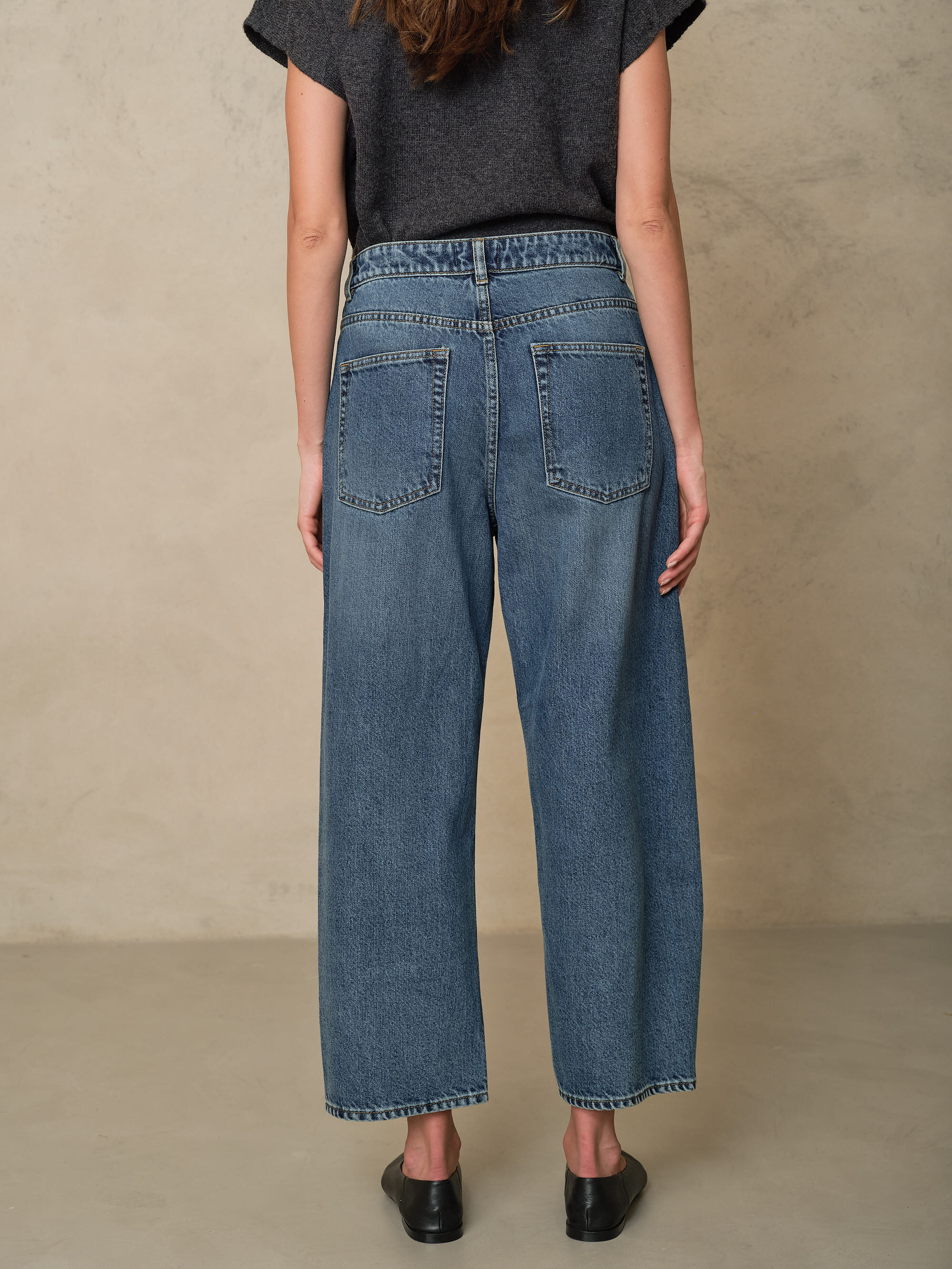 Rosie mid wash twist front jeans showing the back pockets and hem, back view