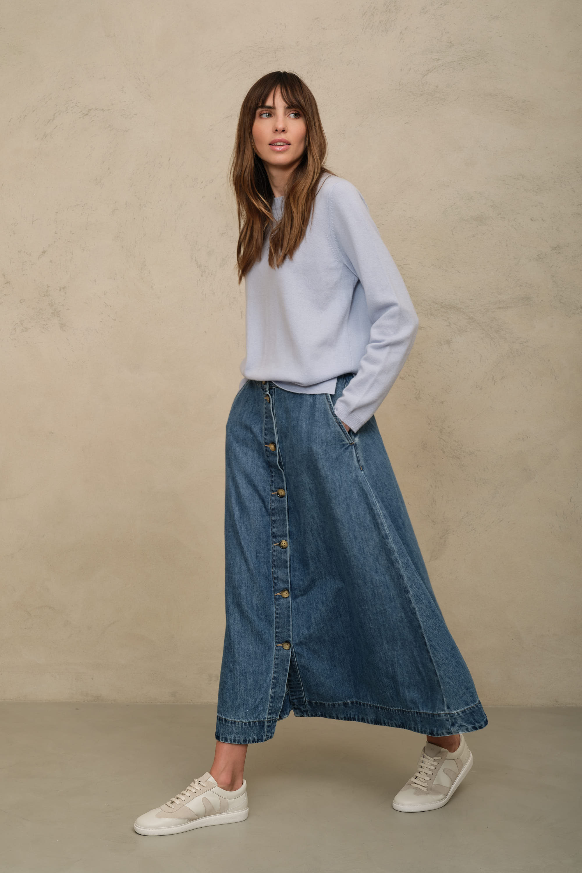Imogen mid wash denim skirt worn with a pale blue jumper and white trainers