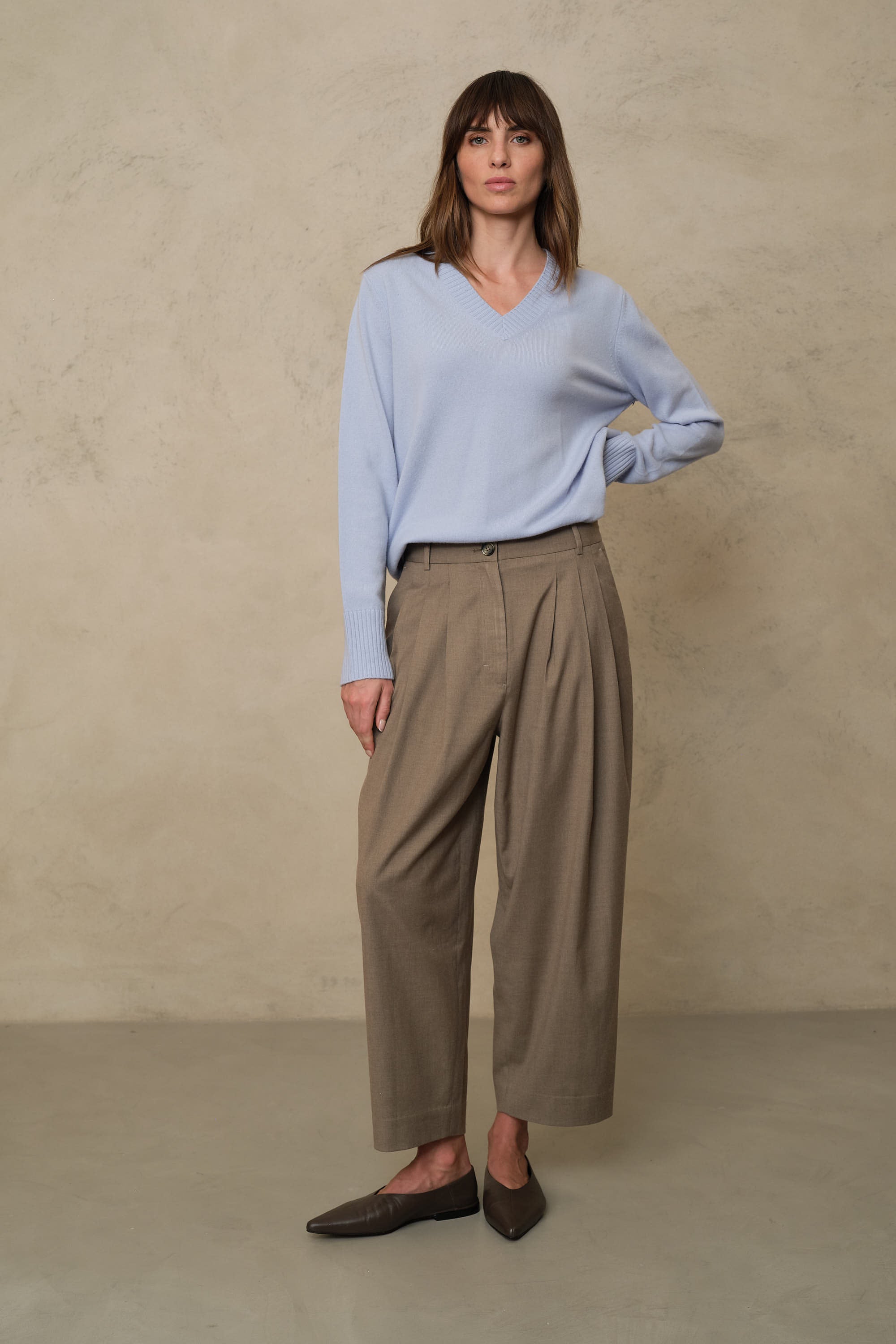 Taupe pleat front trousers worn with the Nian pale blue V neck jumper for an easy tonal outfit