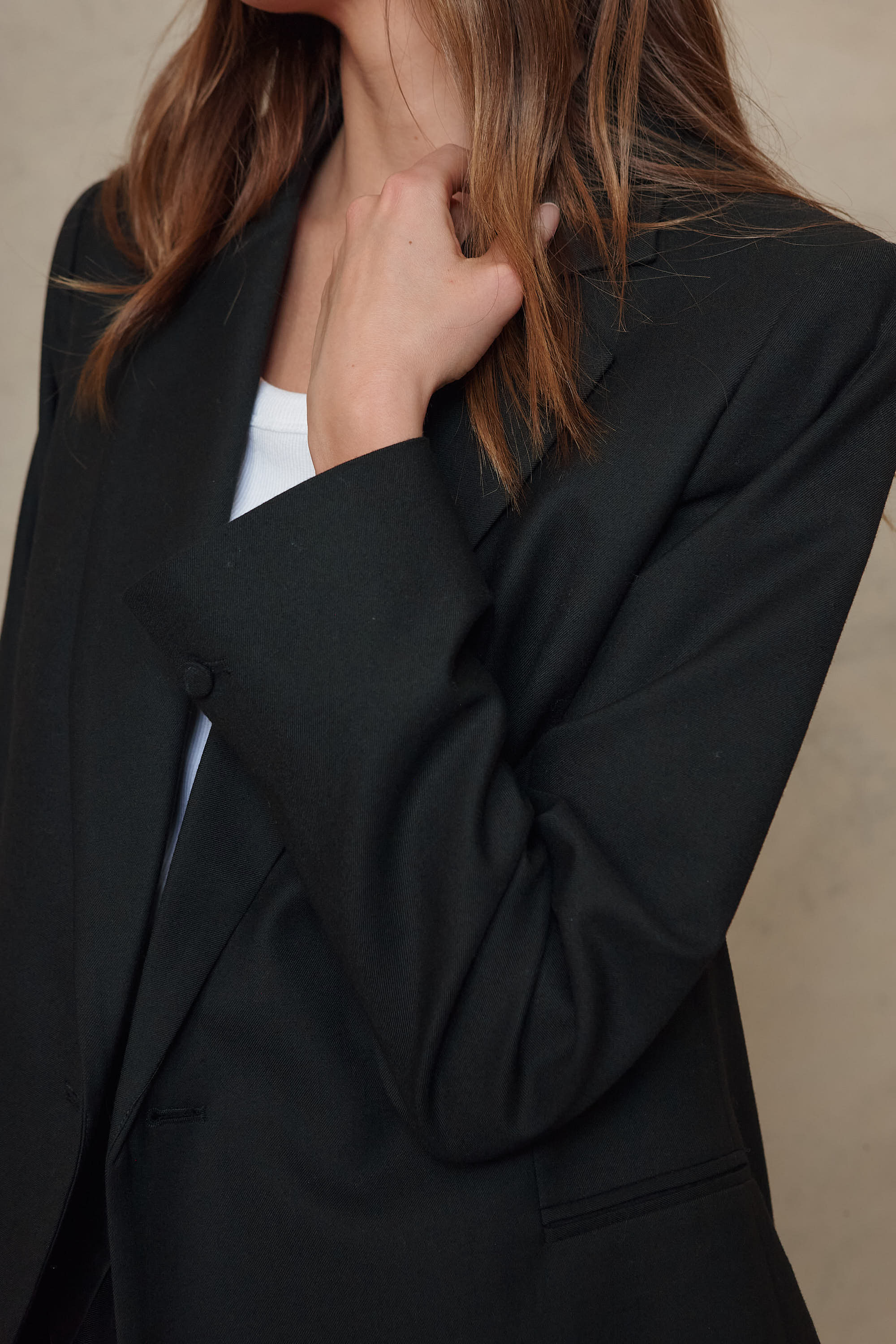 Josephine black wool blend blazer worn open over a white top, close up