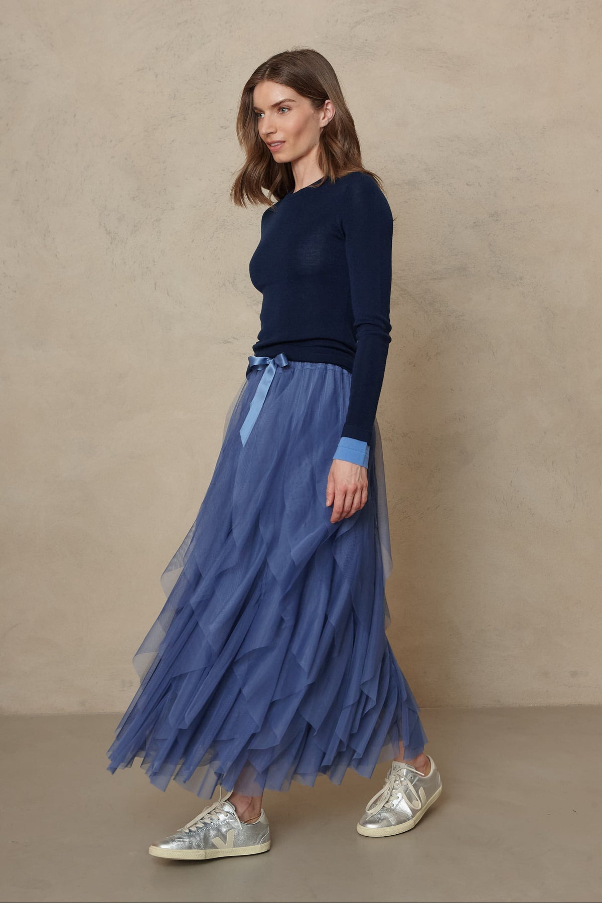 Full length view of the Iris tulle maxi skirt in lapis blue with a navy knit, walking