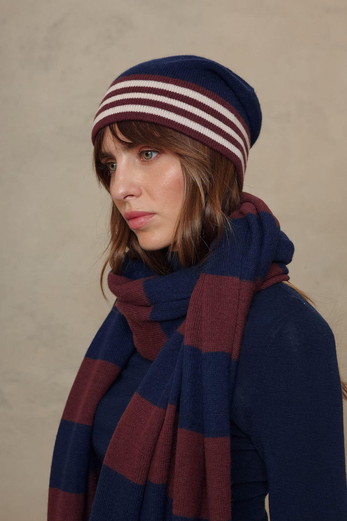 Close up of the Carmel cashmere blend scarf in navy and burgundy with the Zinnie beanie in navy, side view