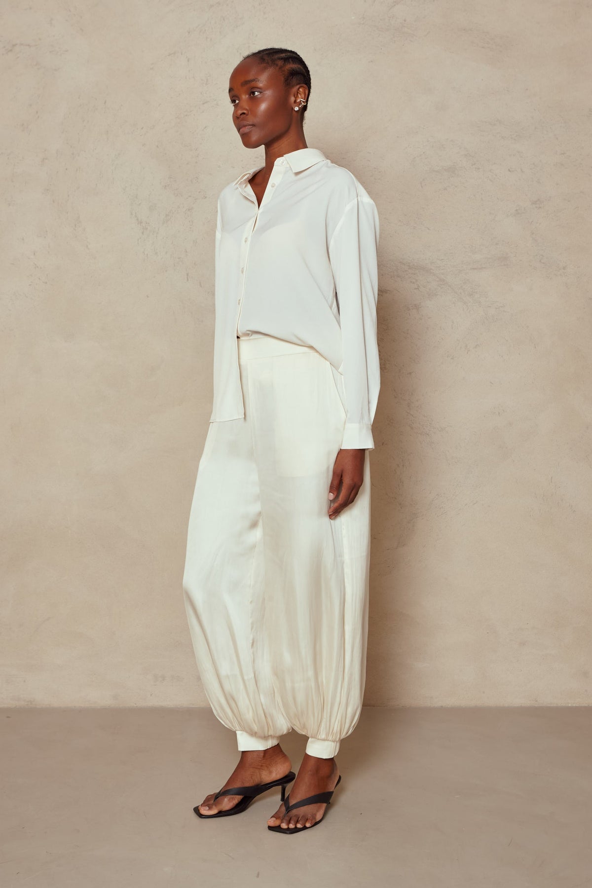 Maeve balloon trousers in ivory with an ivory shirt and heeled sandals, side view