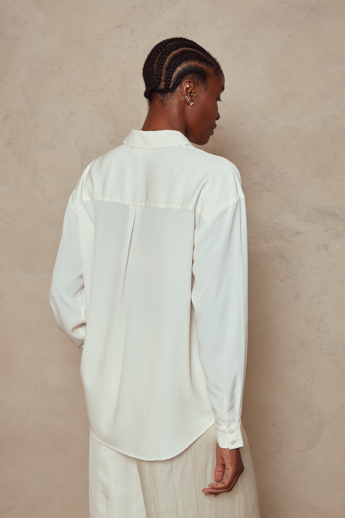 Back view of the Margot shirt in ivory, showing the dropped shoulder and curved hem