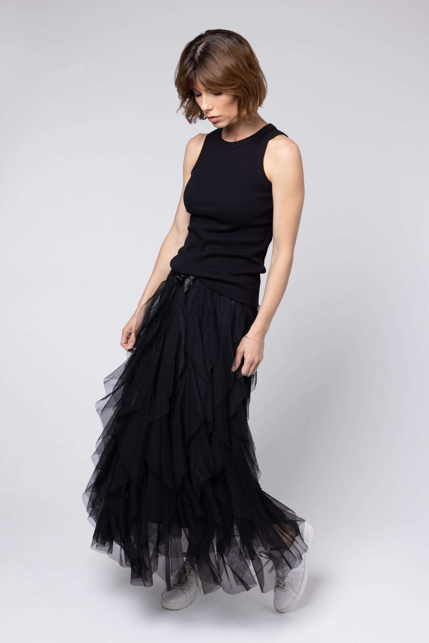 Model wearing black vest and black tulle maxi skirt