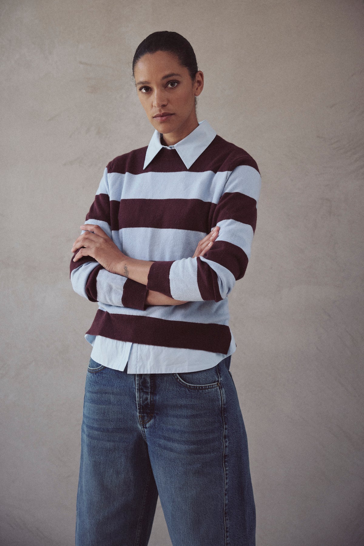Blue striped jumper layered over a blue shirt with the collar and cuffs showing