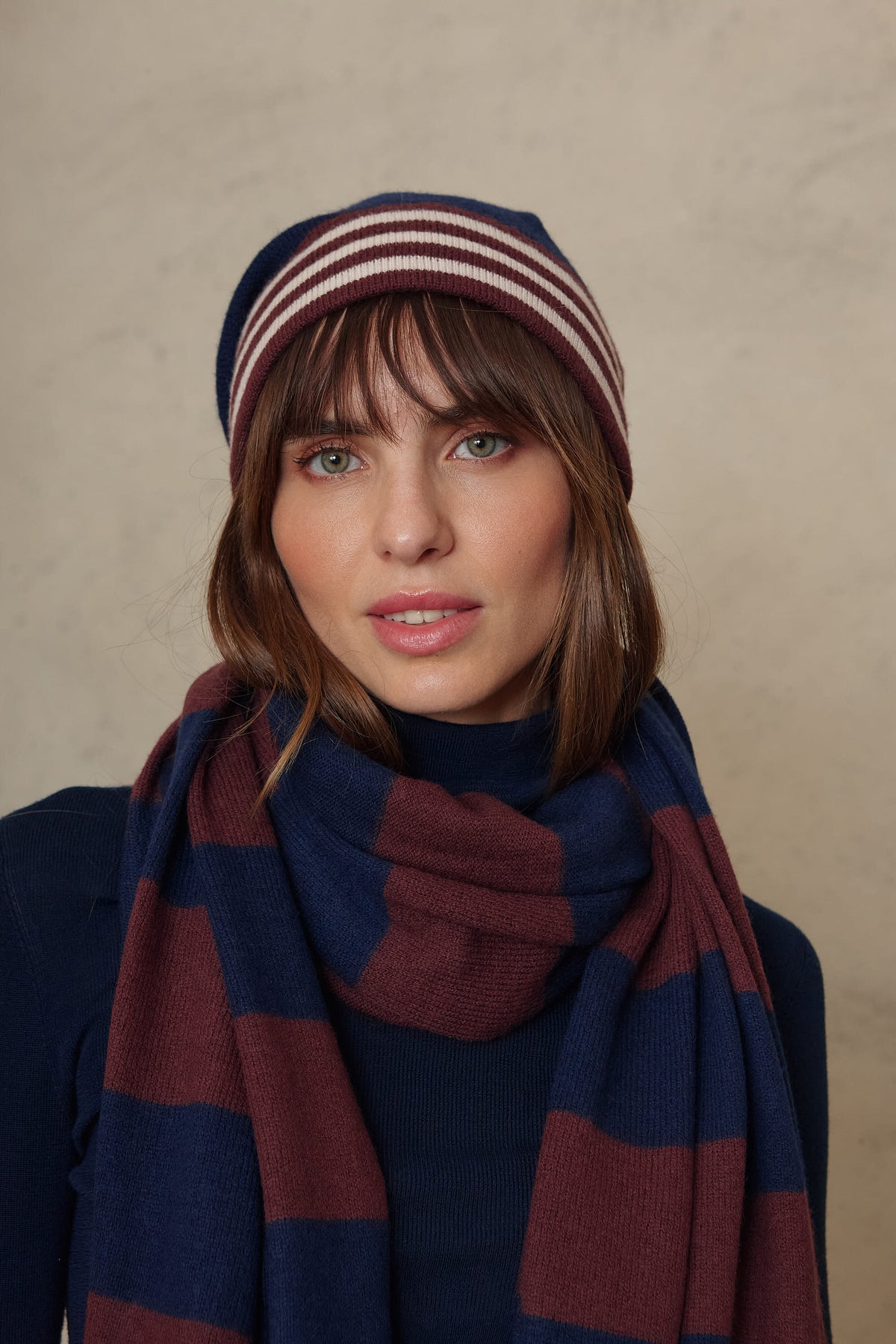 Zinnie cashmere blend beanie in navy worn with the Carmel cashmere blend scarf in navy and burgundy