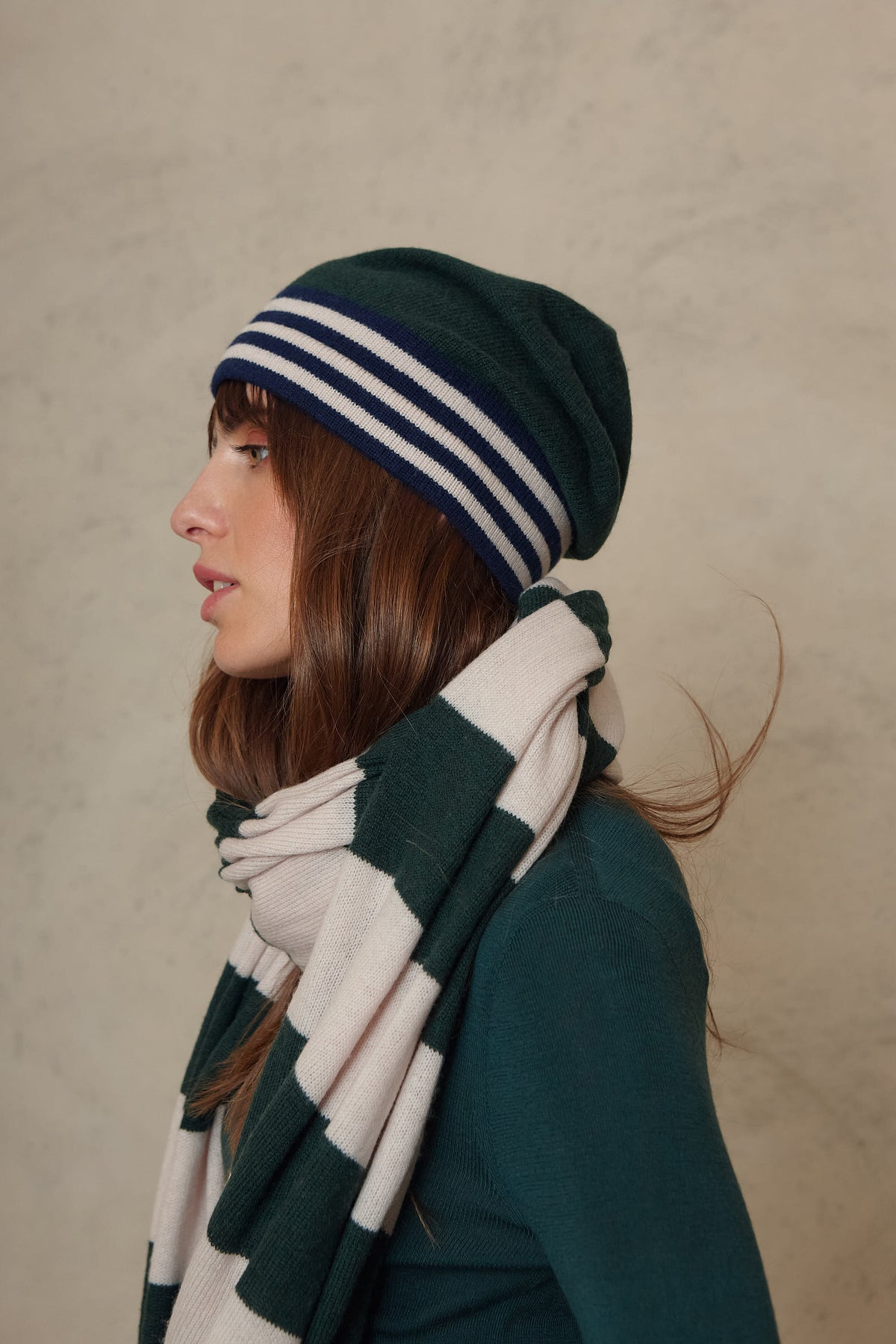 Zinnie cashmere blend beanie in bottle green worn with the Carmel cashmere blend scarf in soft stone and bottle green