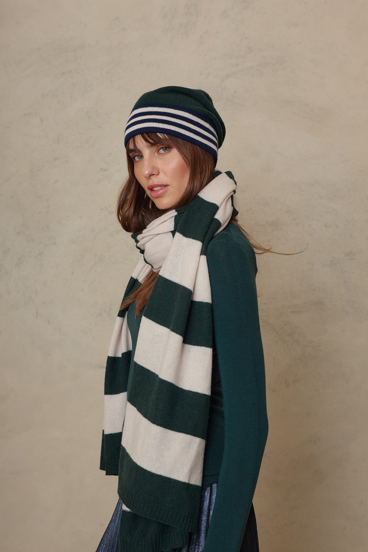 Zinnie cashmere blend beanie in bottle green worn with the Carmel cashmere blend scarf in soft stone and bottle green