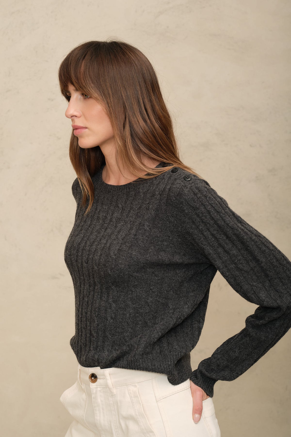 Side view of the Cory charcoal cable knit jumper with a hand on the hip