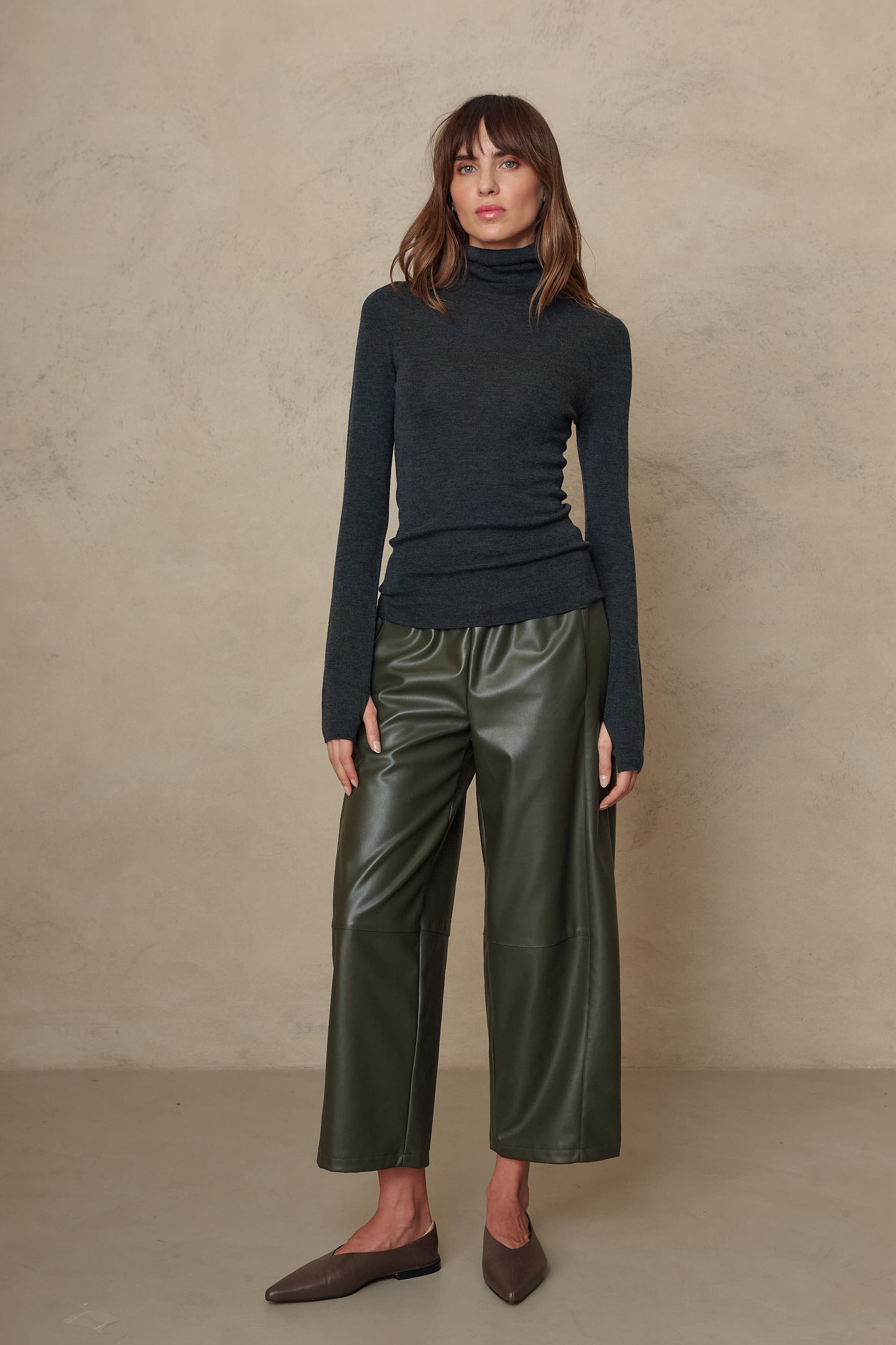 Gwyneth charcoal fine merino roll neck styled with olive faux leather trousers and brown loafers