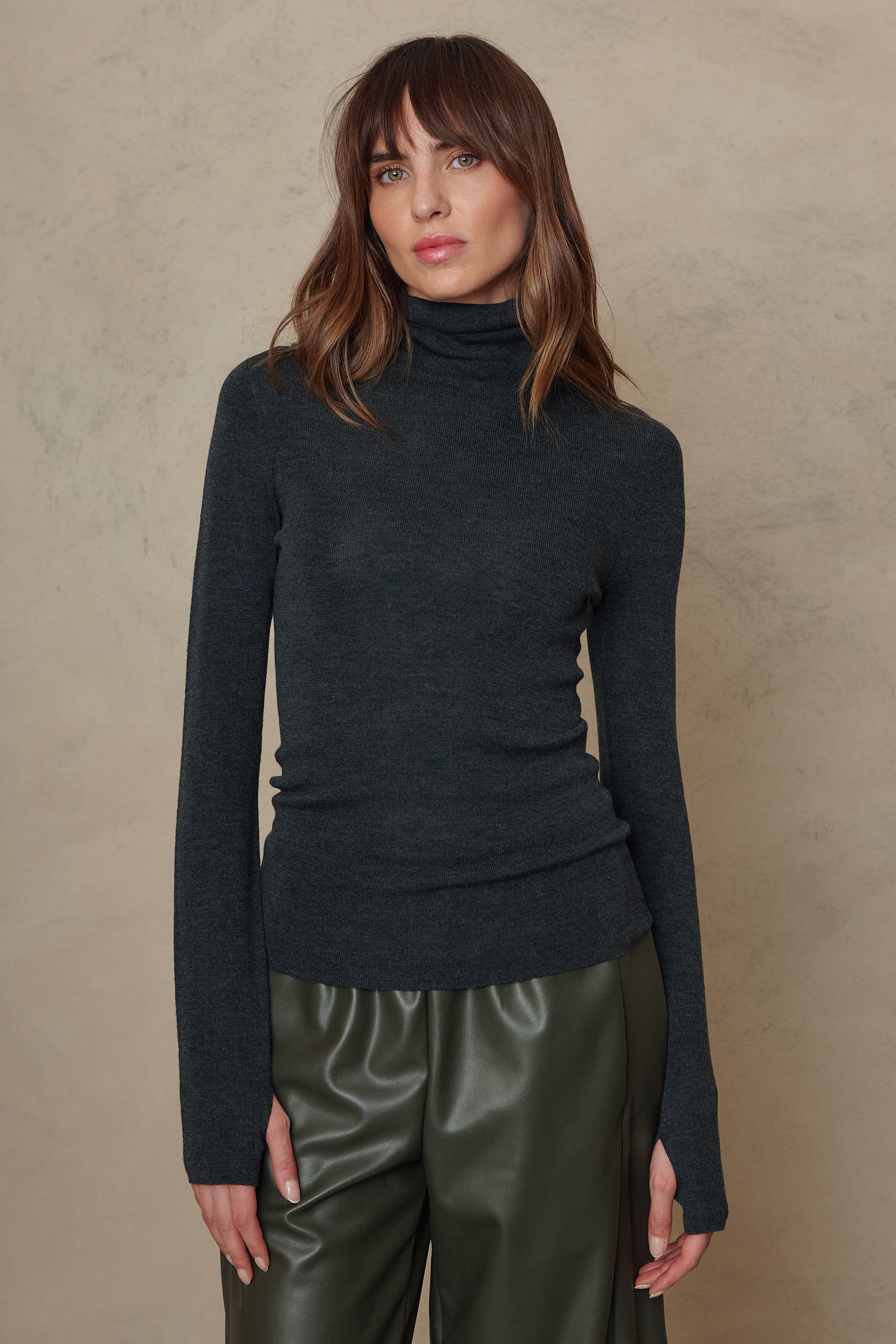 Gwyneth charcoal fine merino roll neck worn with olive faux leather trousers