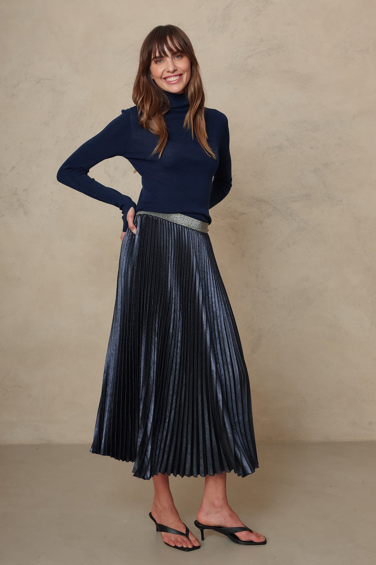 Gwyneth fine merino roll neck in navy worn with the Mia pleated skirt in navy