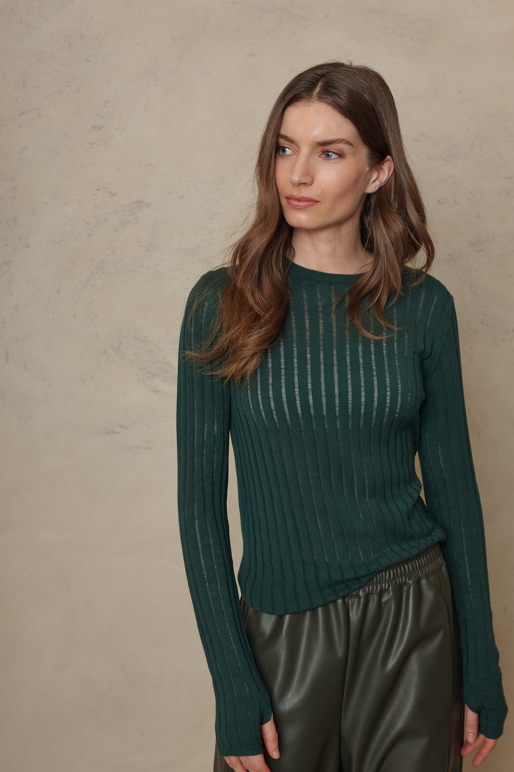 Iggy bottle green sheer rib jumper with a hand in the pocket, three quarter view
