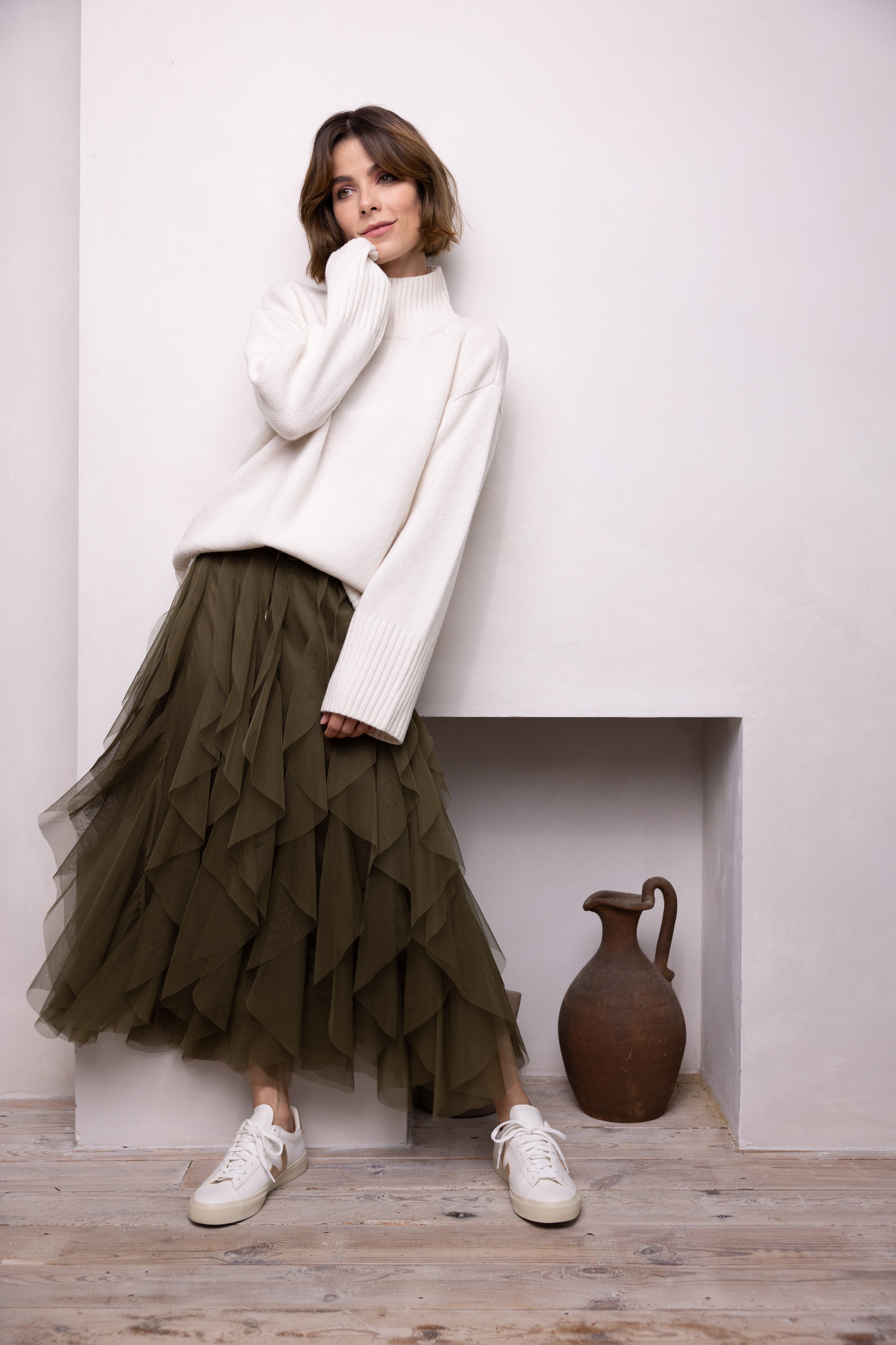 model wearing white jumper and khaki tulle skirt