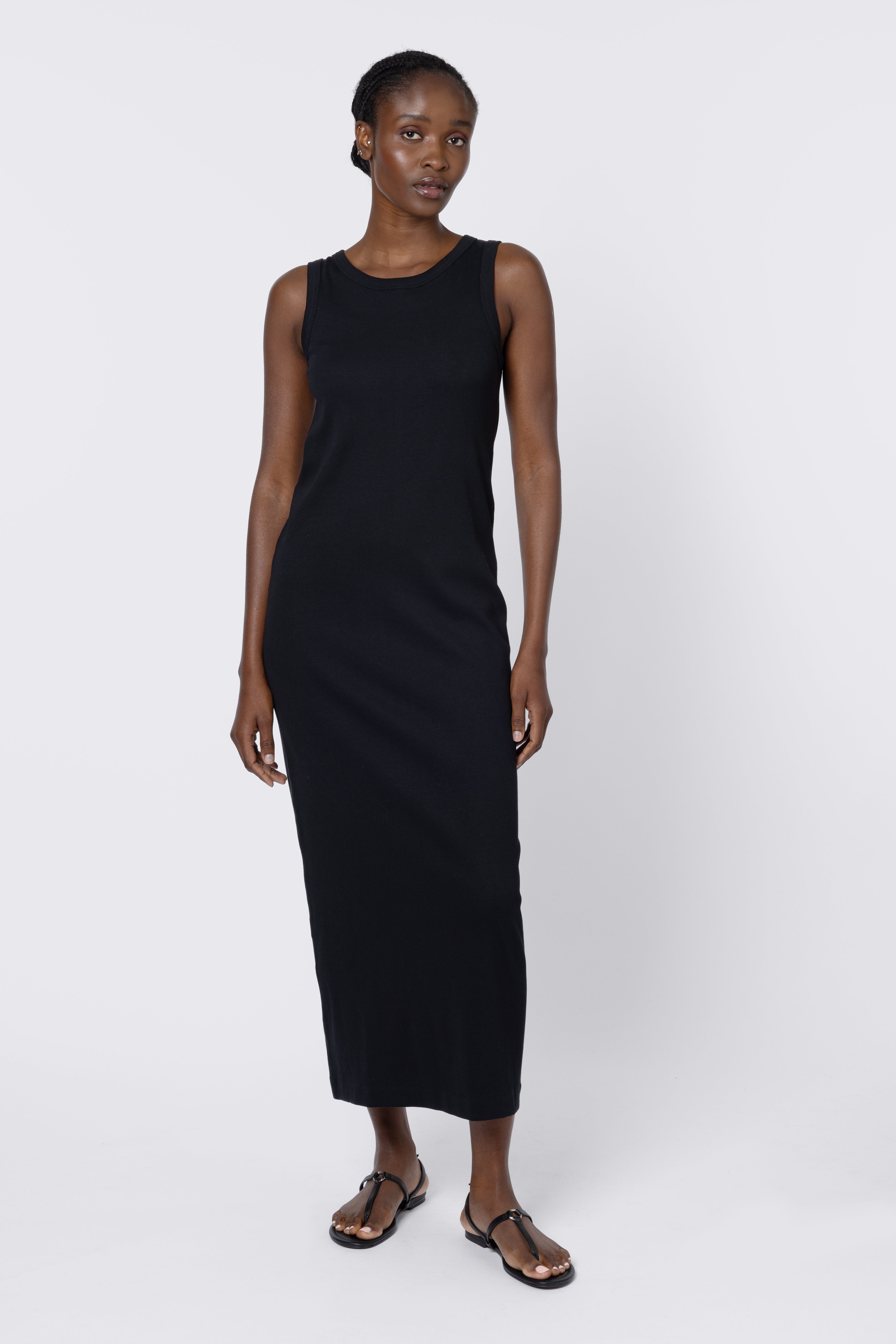 Woman wearing a black sleeveless dress on a white background