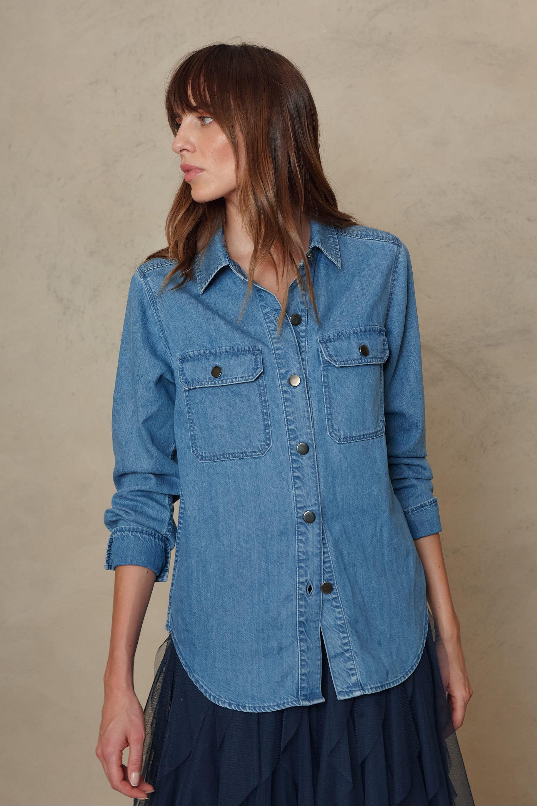 Joni mid wash denim shirt worn open over a navy tulle skirt, side view