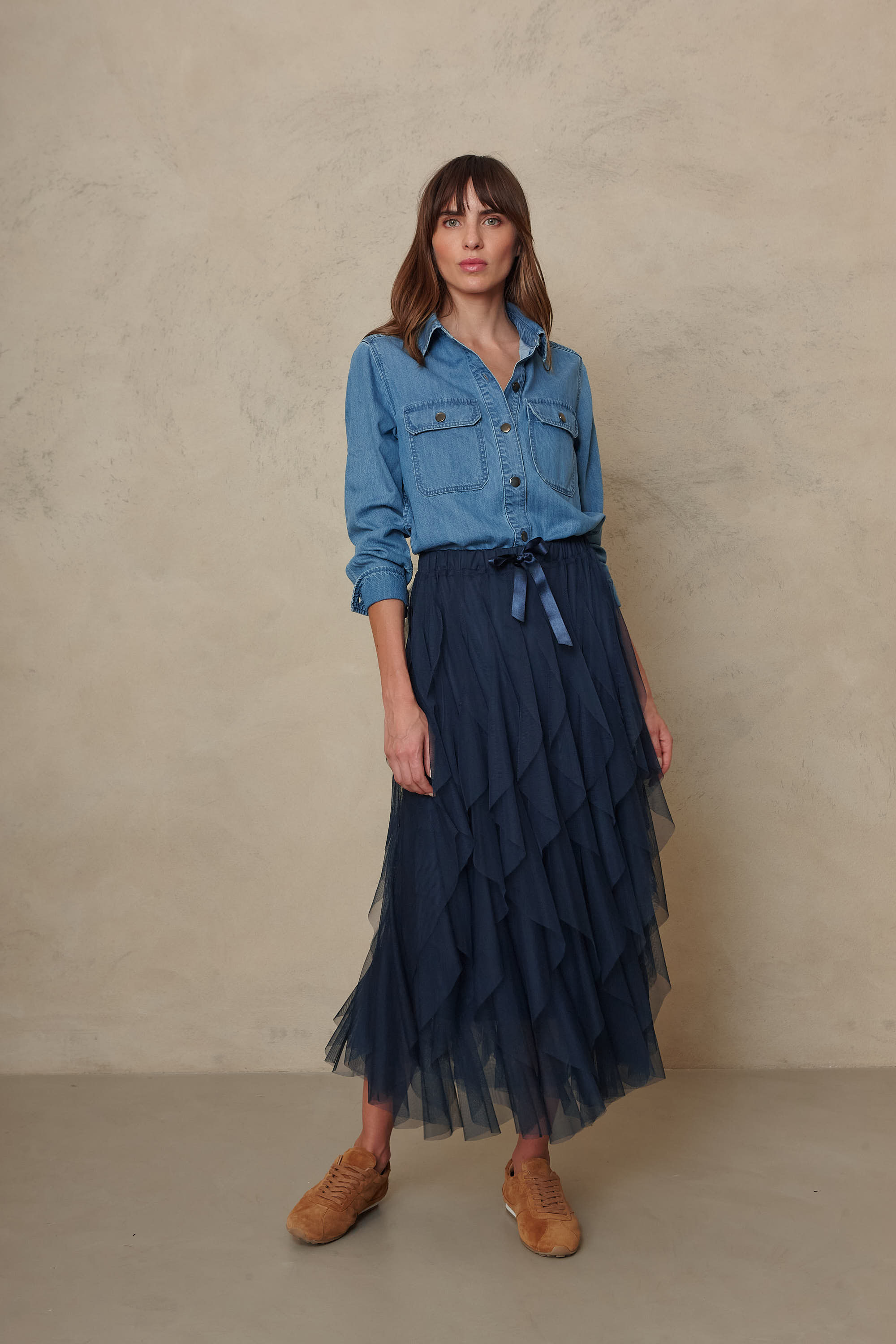 Joni mid wash denim shirt worn with a navy tiered tulle skirt and tan ankle boots