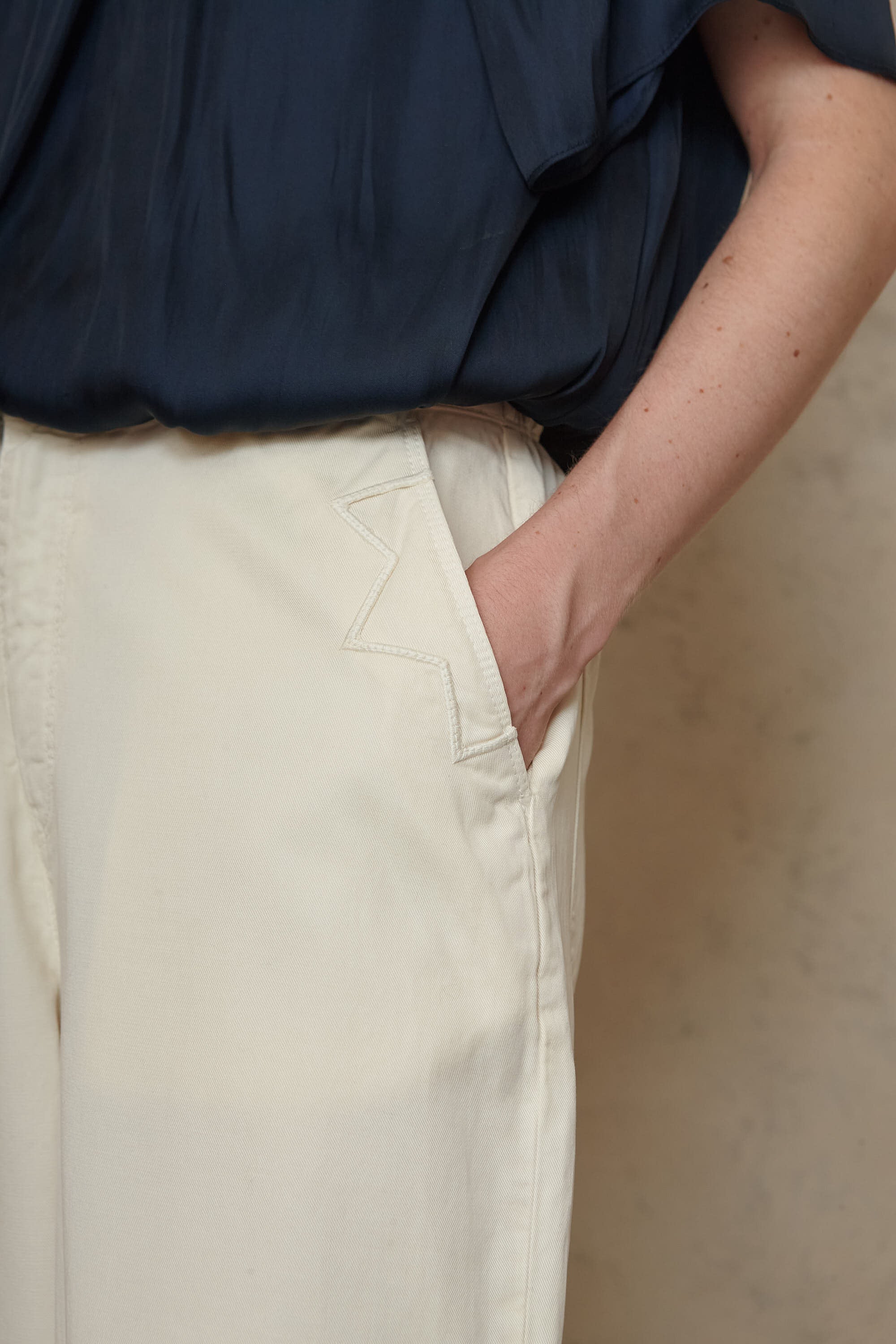 Kate ecru cargo trousers showing the embroidered pocket detail, close up