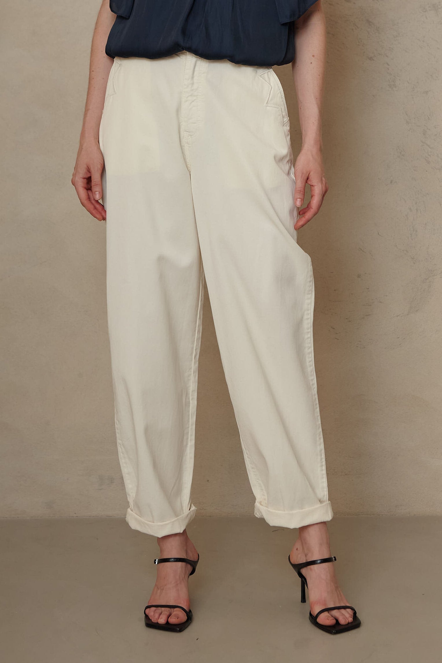Kate ecru cargo trousers with a cuffed hem, worn with a navy blouse and black sandals