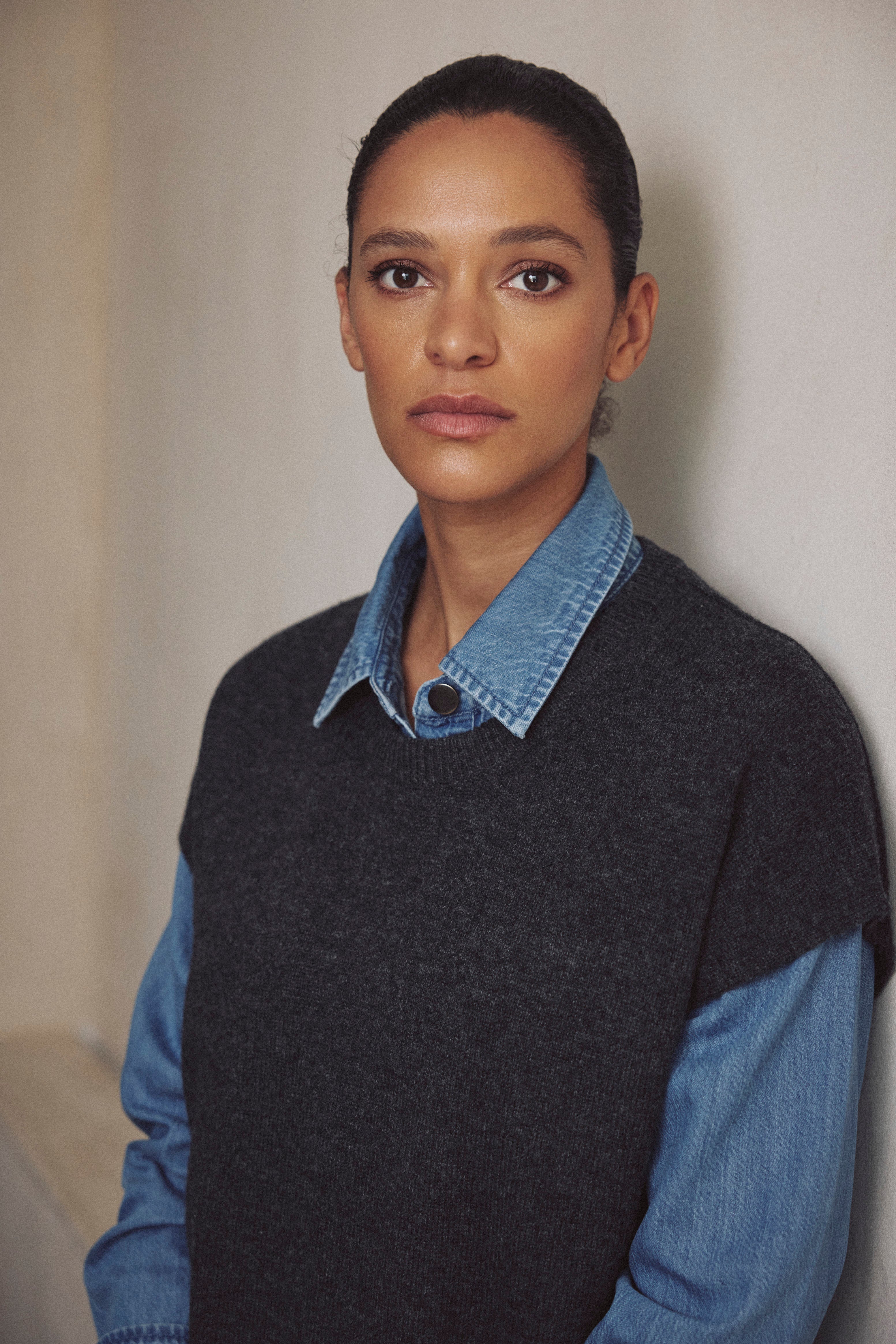 Ora charcoal knitted vest layered over a blue shirt, front view