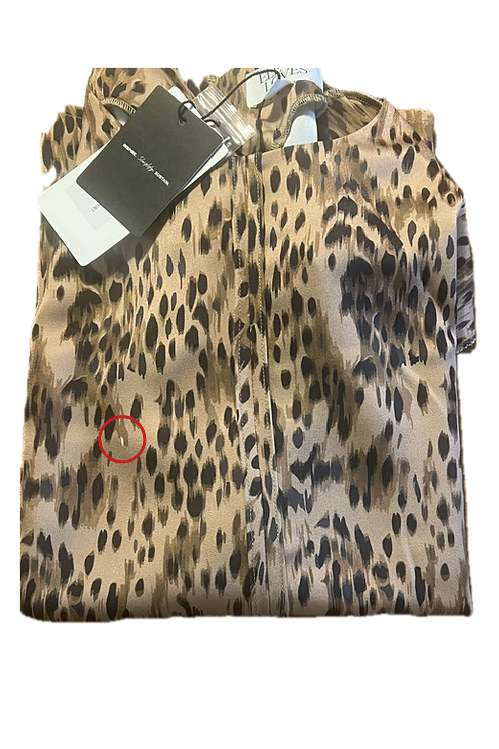 Close up of the small white print mark, circled, on the Skylar satin T Shirt in animal print