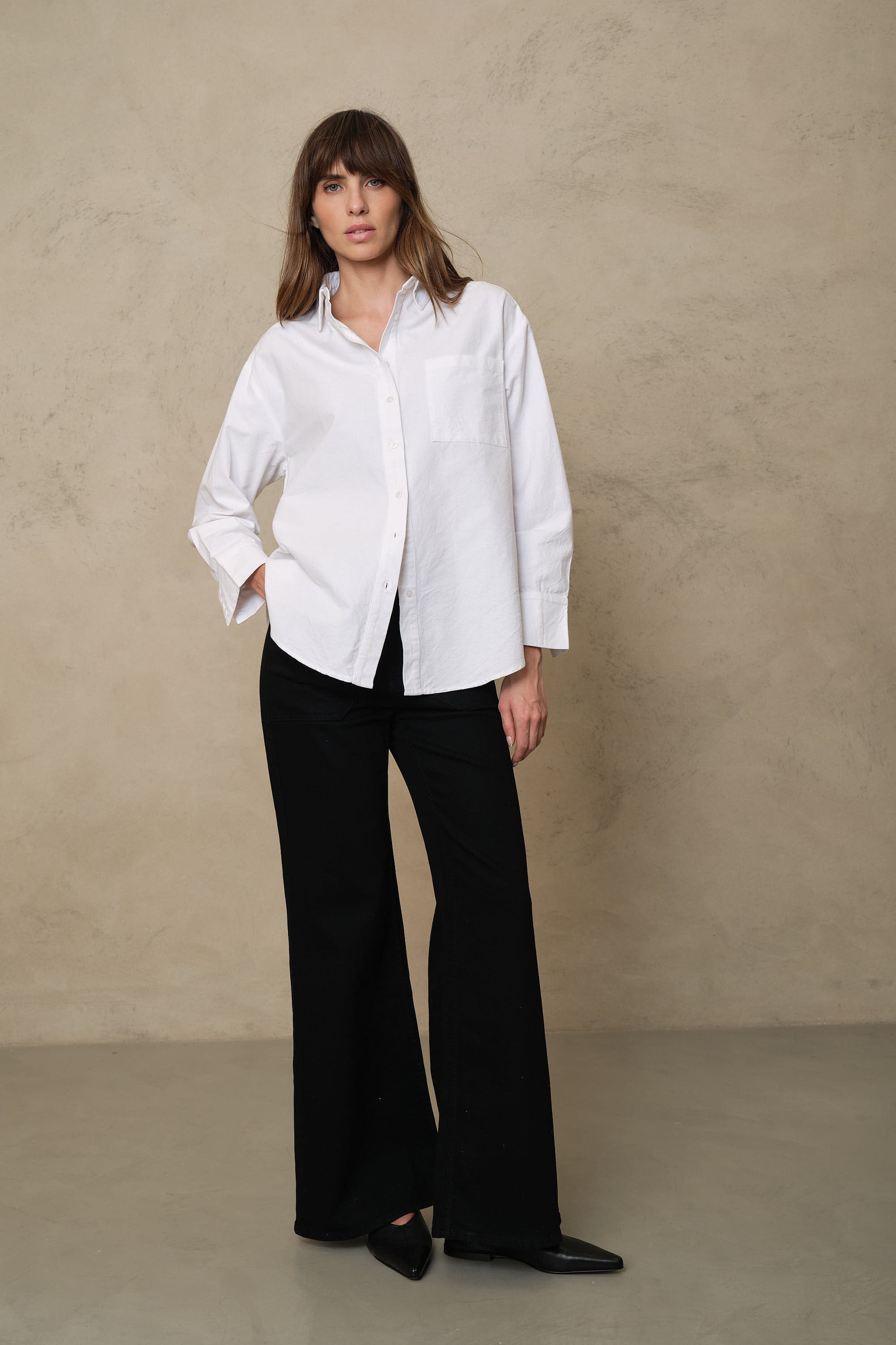 Black wide leg jeans worn with an oversized white shirt for an easy monochrome outfit