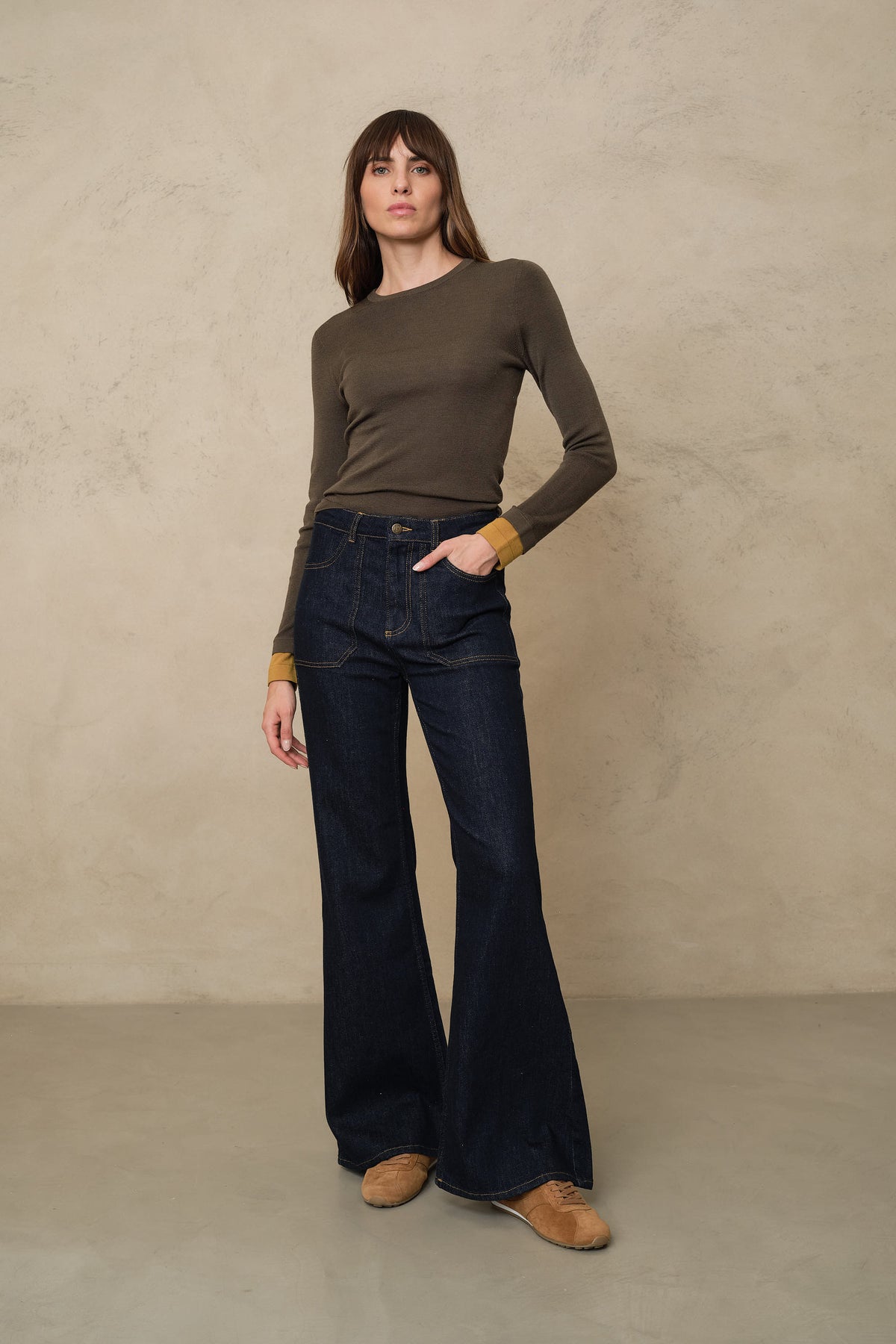 Trinny fine merino crewneck in dark olive with a mustard sleeve worn with the Frankie wide leg jeans in rinse wash